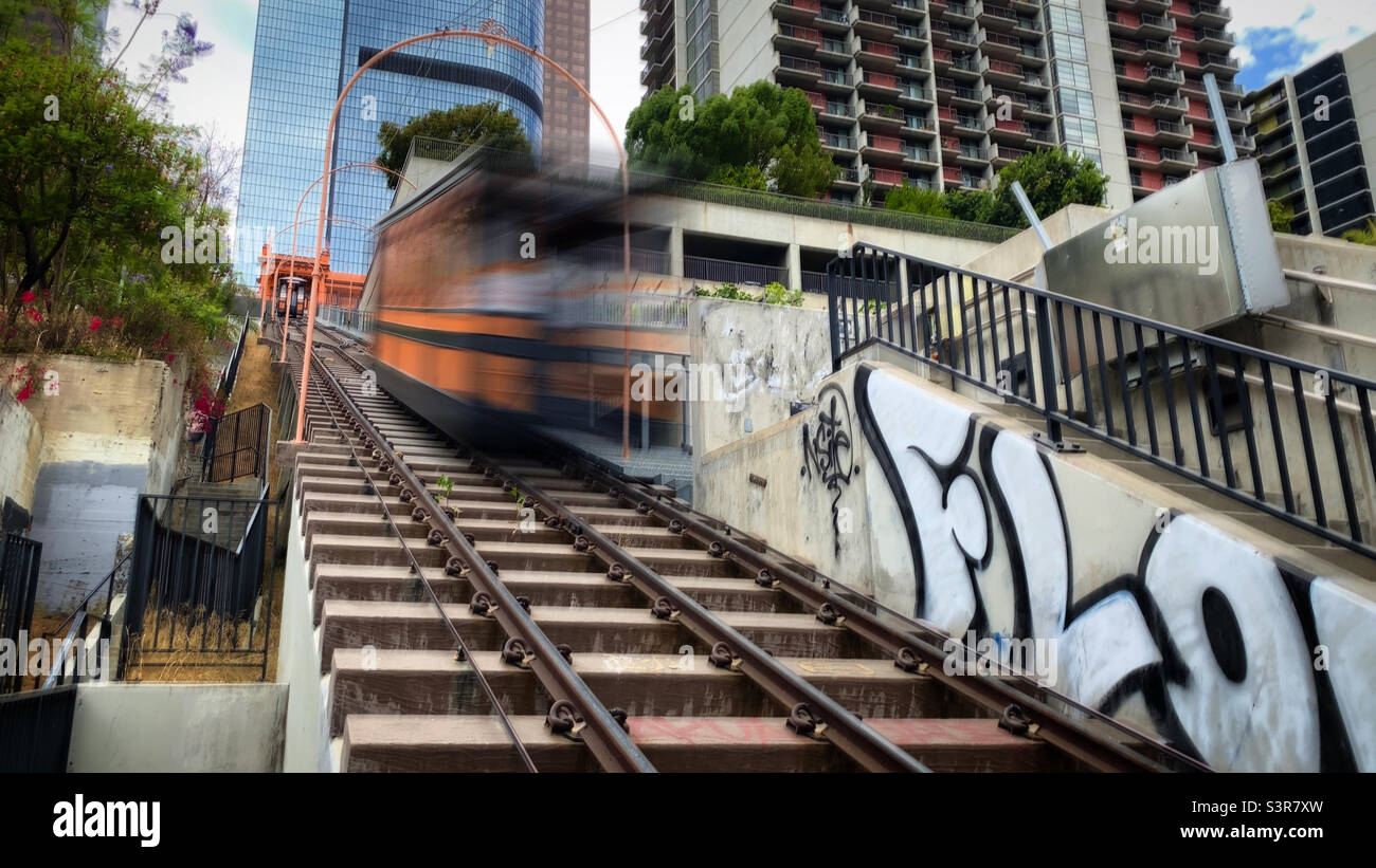 LOS ANGELES, CA, 2021. JULI: Bewegter Zug mit Bewegungsunschärfe auf der historischen Angel's Flight Standseilbahn in Downtown, Wolkenkratzer im Hintergrund Stockfoto