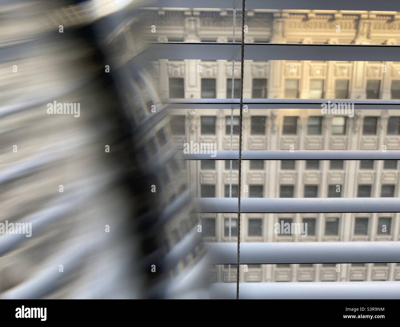 Abstraktes Muster mit Prisma vor dem Kameraobjektiv. Fassade eines historischen Gebäudes durch Fenster mit teilweiser Verzerrung gesehen. Konzentrieren Sie sich auf Jalousien - Smartphone-aufgenommenes Stockfoto