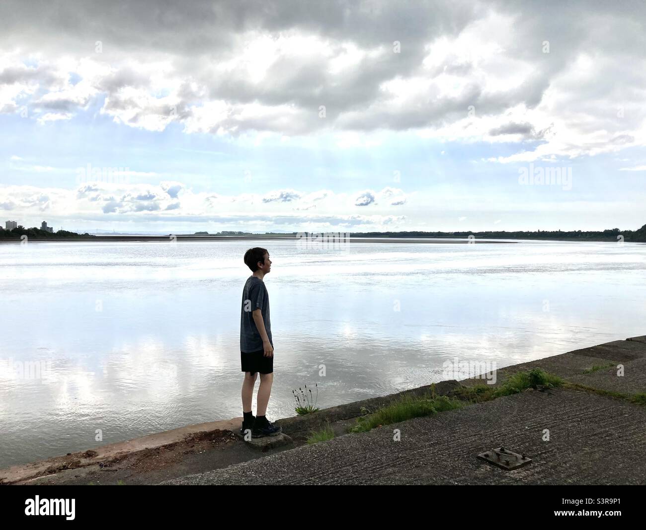 Junge am Ufer des Flusses Mersey Stockfoto