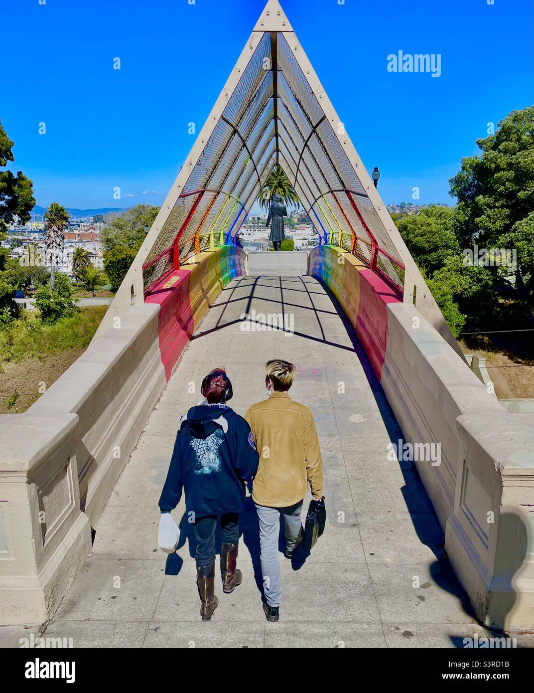 Ein Paar, das über die Regenbogenbrücke im Dolores Park, San Francisco, Kalifornien, geht. - Smartphone-aufgenommenes Stockfoto
