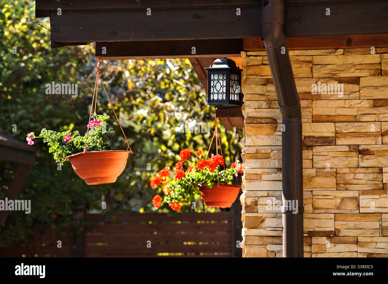 Blumen vor dem Haus in hängenden Töpfen Stockfoto