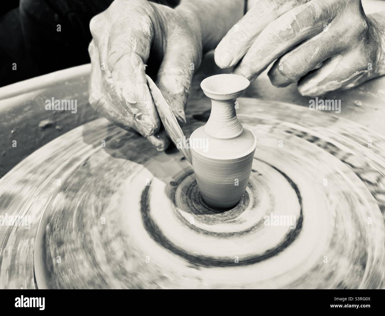 Potters Hände machen einen Miniaturtopf auf einem Rad Stockfoto
