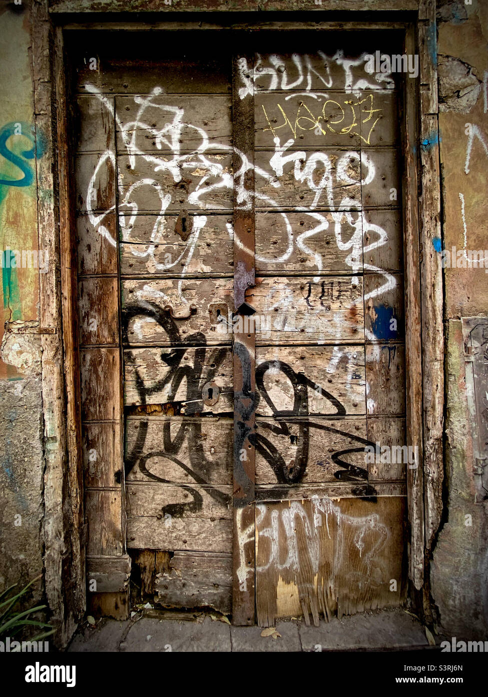 Graffidierten hölzernen Eingang in einem verlassenen Gebäude Stockfoto