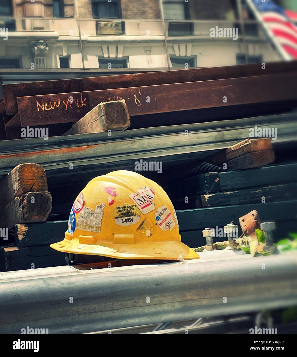 Nahaufnahme eines gelben Hardhuts von Bauarbeitern auf einem Stahlträger auf einer Baustelle, New York City, USA, 2022 - Smartphone-aufgenommenes Stockfoto