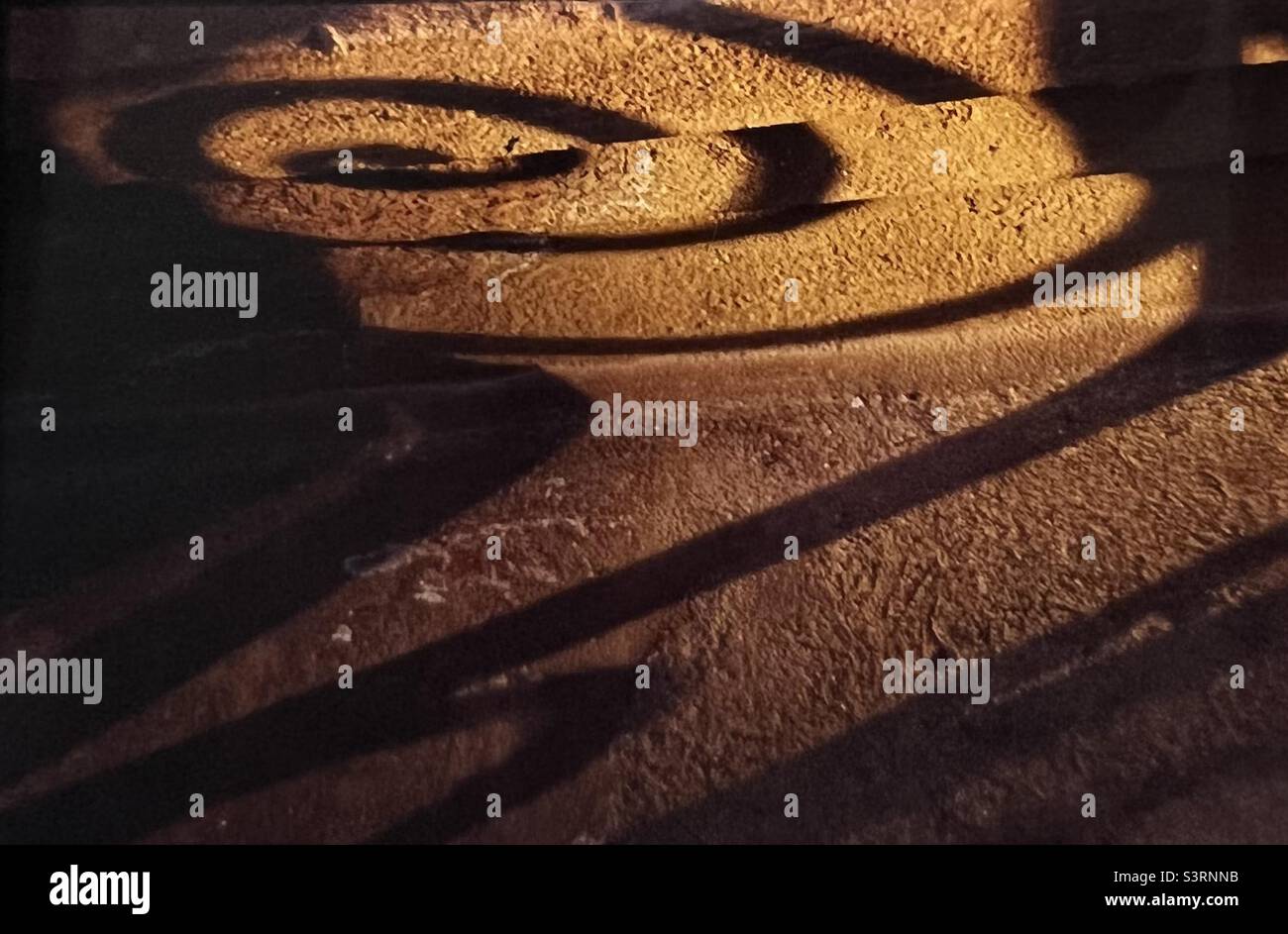 Schatten des Geländers auf dem Gebäude Goldenes Licht - Smartphone-aufgenommenes Stockfoto