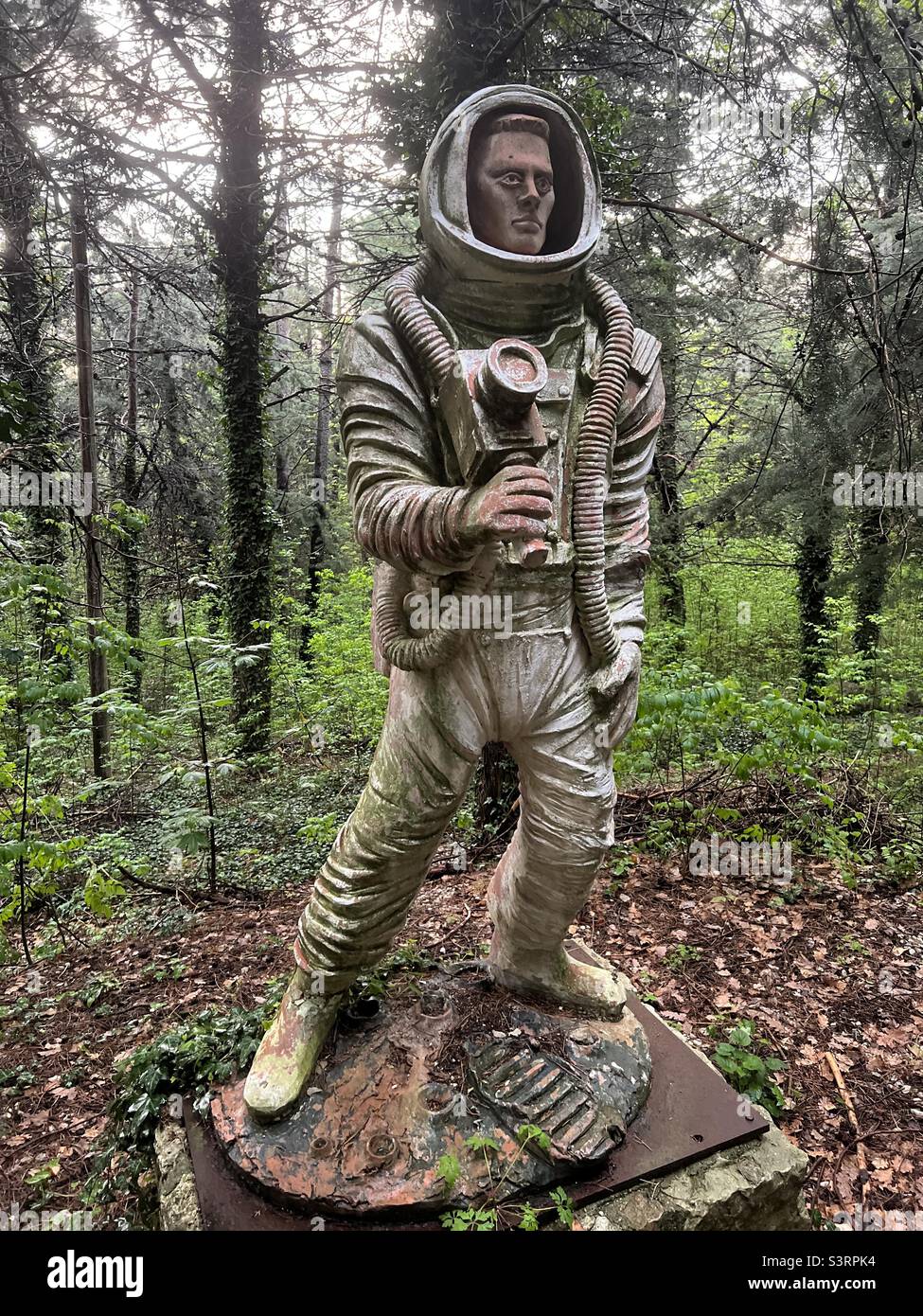 Kreative Astronautenstatue in einem Garten - Smartphone-aufgenommenes Stockfoto