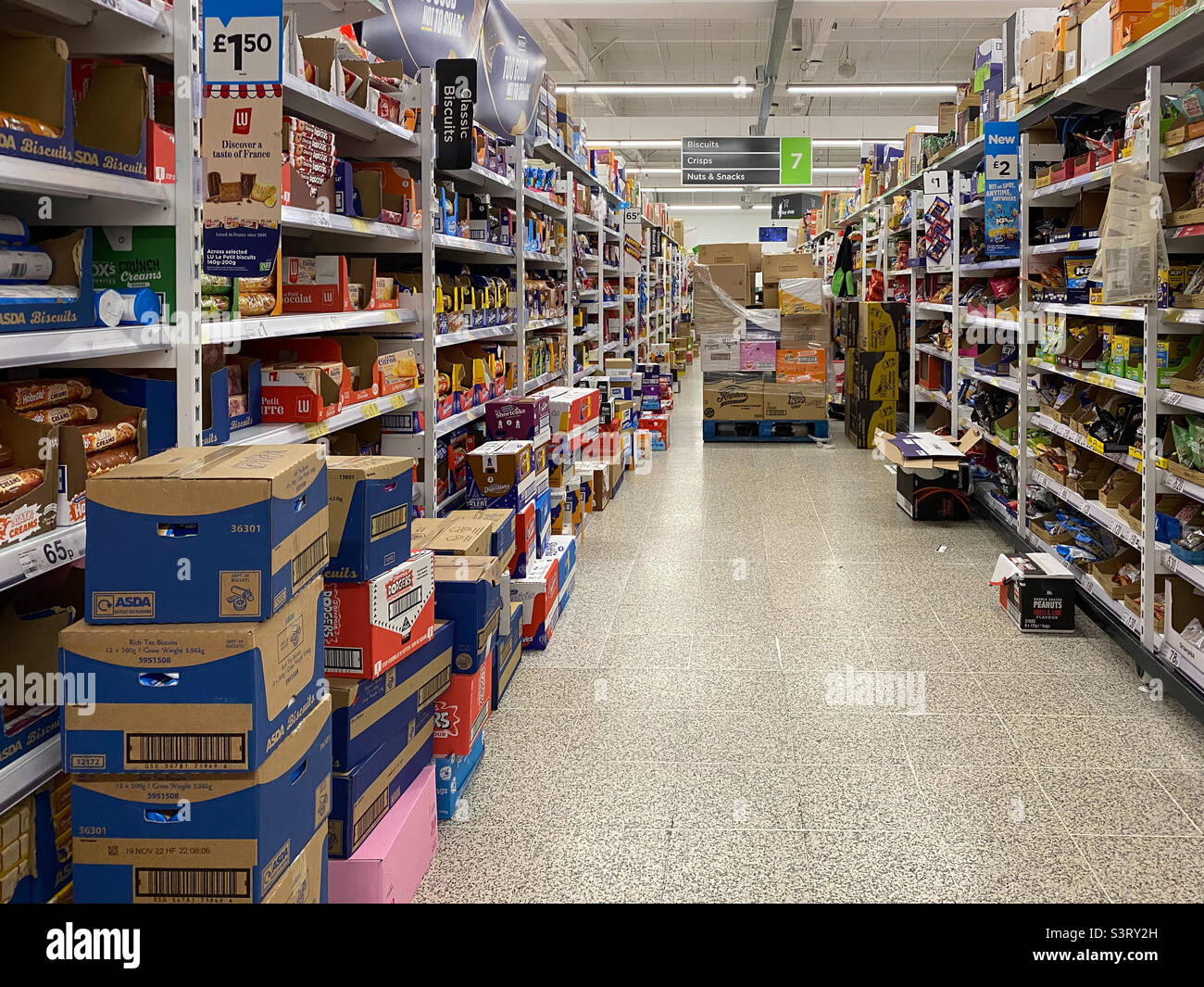 Schachteln mit Produkten, die entlang eines Supermarktgangs gelagert werden und bereit sind, in
