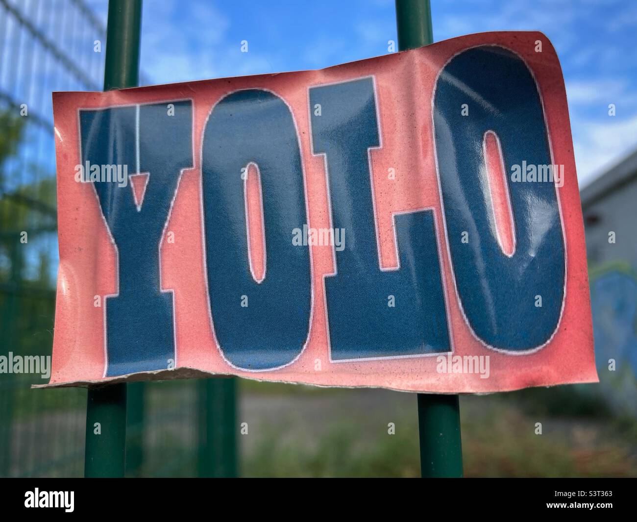 Ein YOLO-Aufkleber auf einem Zaun Stockfoto