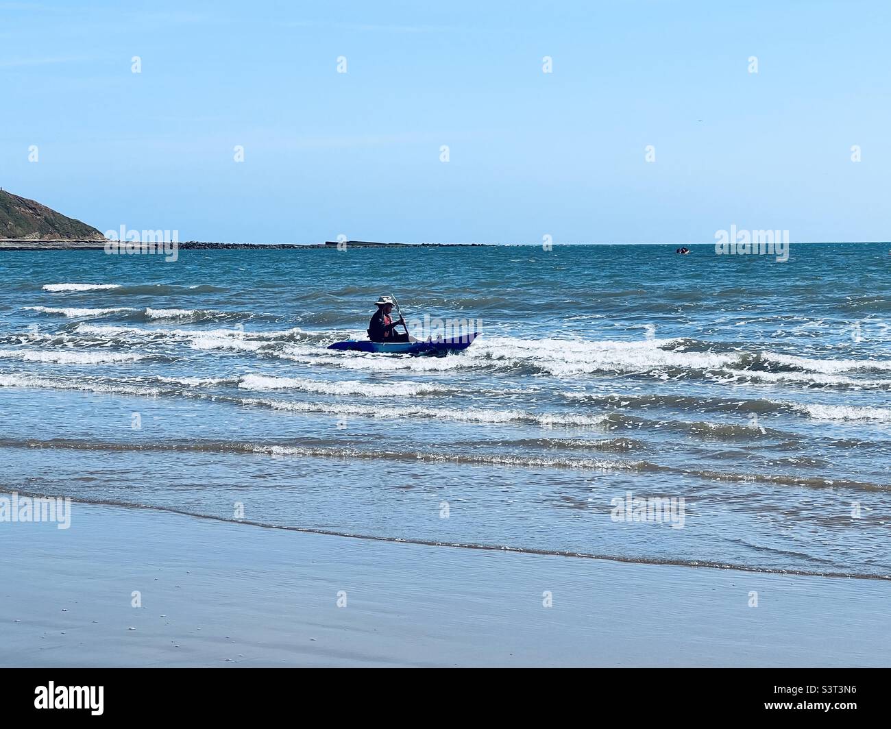 Mann paddelt mit einem kleinen Boot in seichtem Wasser Stockfoto
