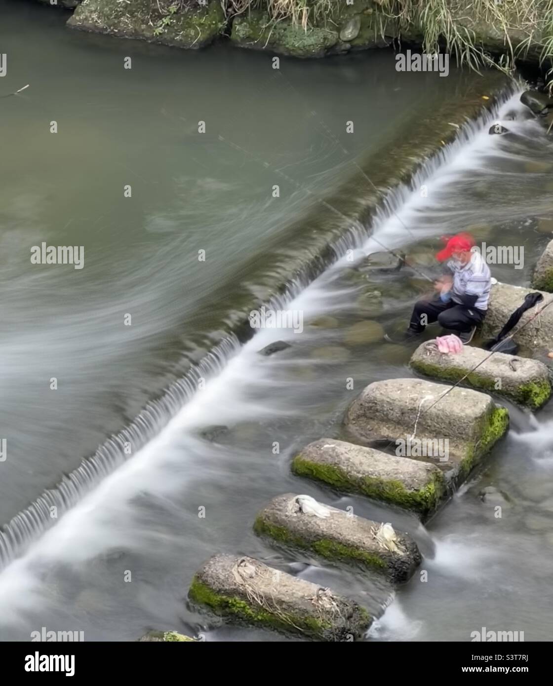 Angeln im Fluss - Smartphone-aufgenommenes Stockfoto