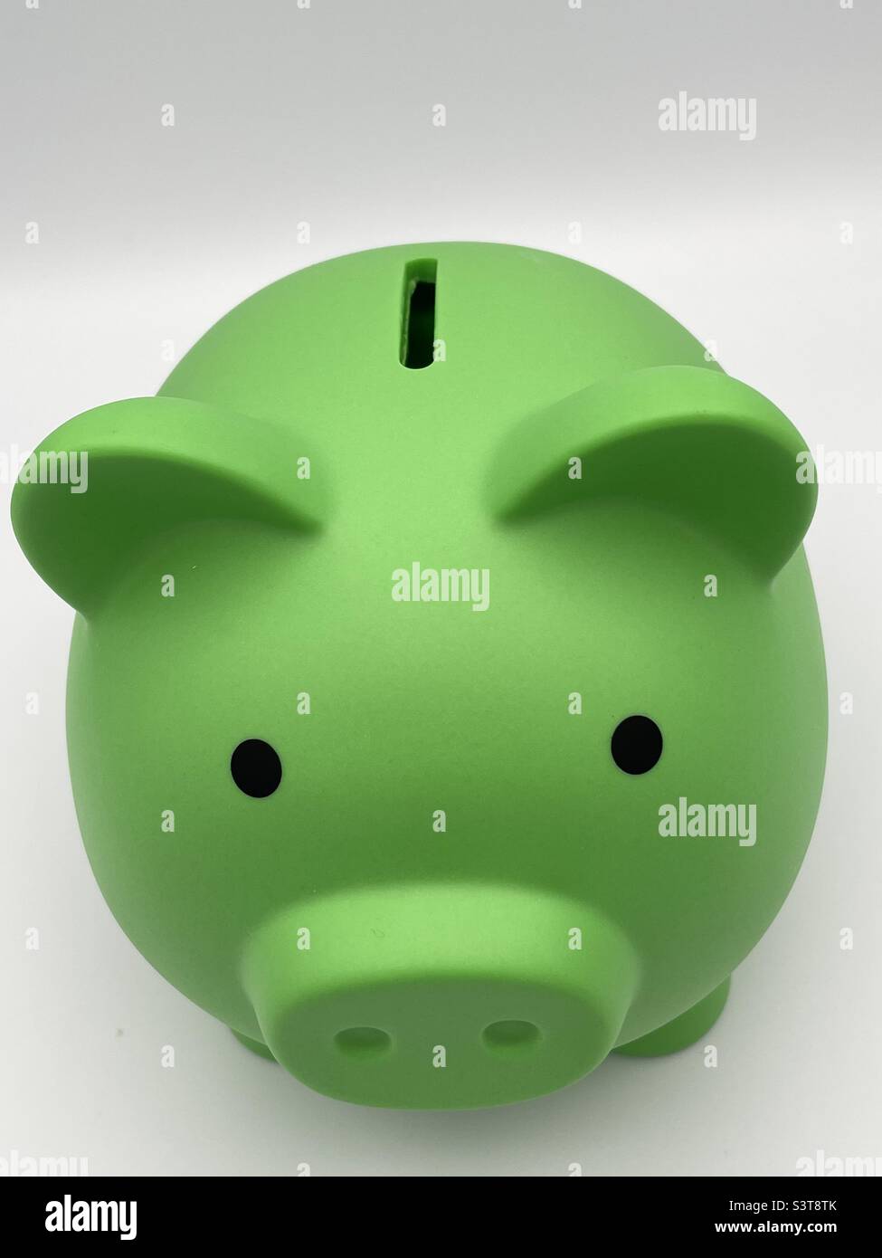 Ein Blick auf ein lindgrünes Sparschwein. - Smartphone-aufgenommenes Stockfoto