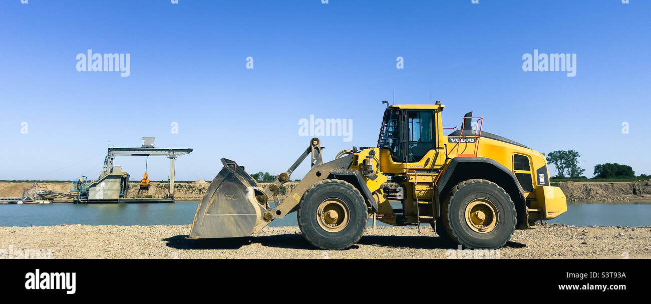 Radlader in einem Sandbruch an einem Flussufer - Smartphone-aufgenommenes Stockfoto