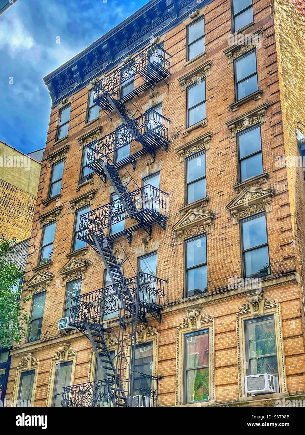 Altes Sandsteingebäude mit schmiedeeisernen Arbeiten, Feuertreppen, architektonischen Ornamenten in New York City, USS Stockfoto