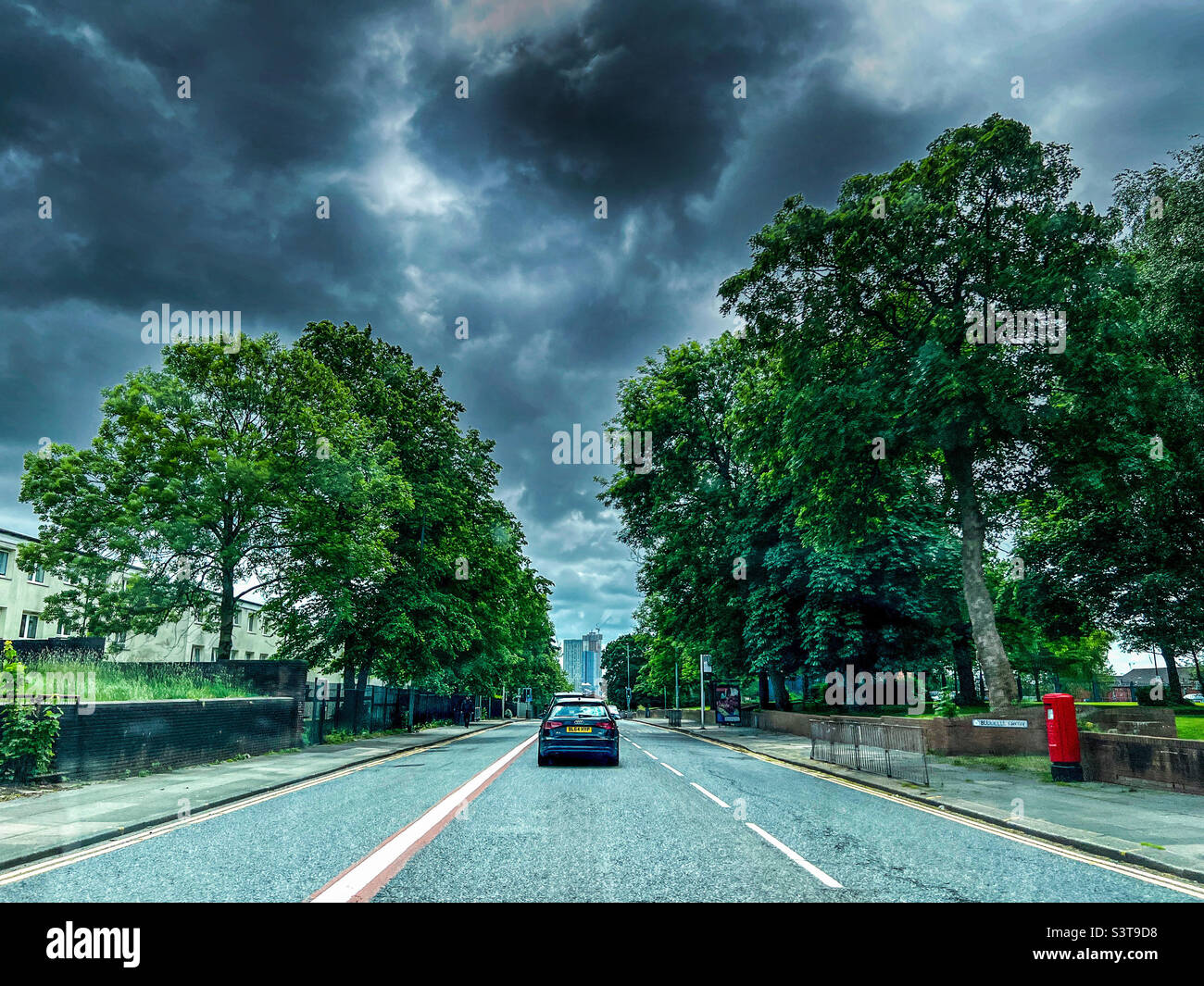 Begraben Sie die New Road in das Stadtzentrum von Manchester bei stürmischem Himmel Stockfoto