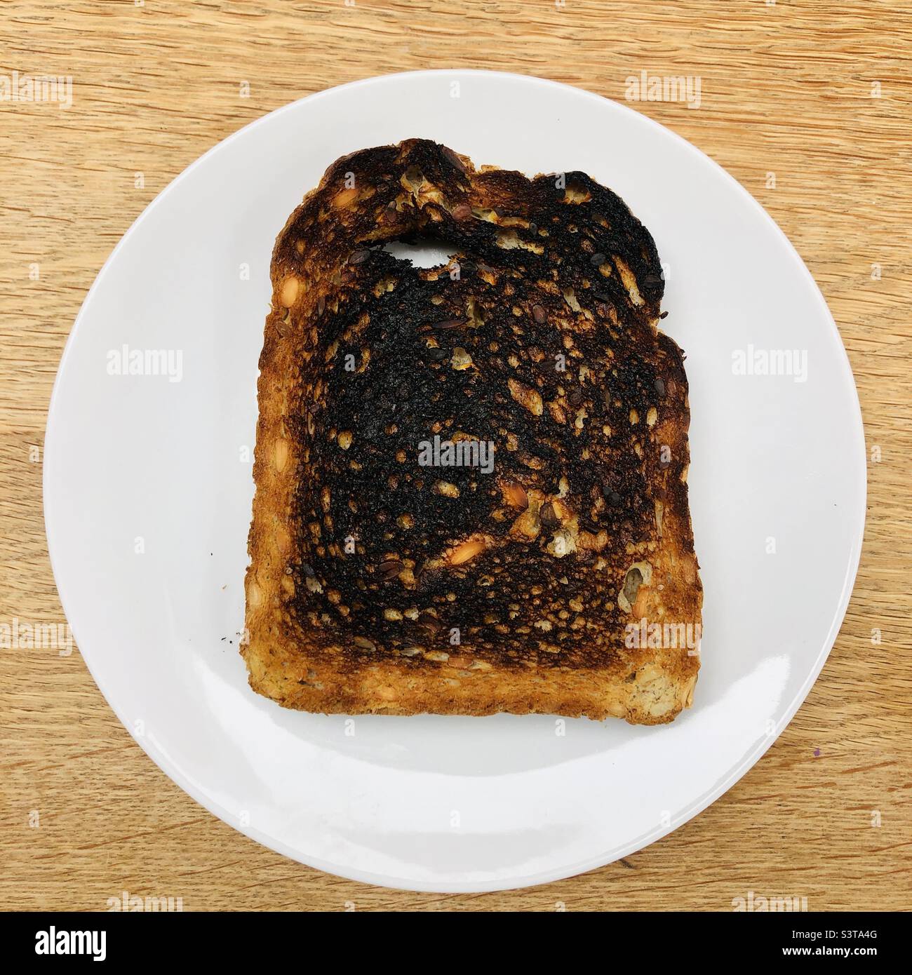 Verbranntem Toast auf einem weißen Teller Stockfoto