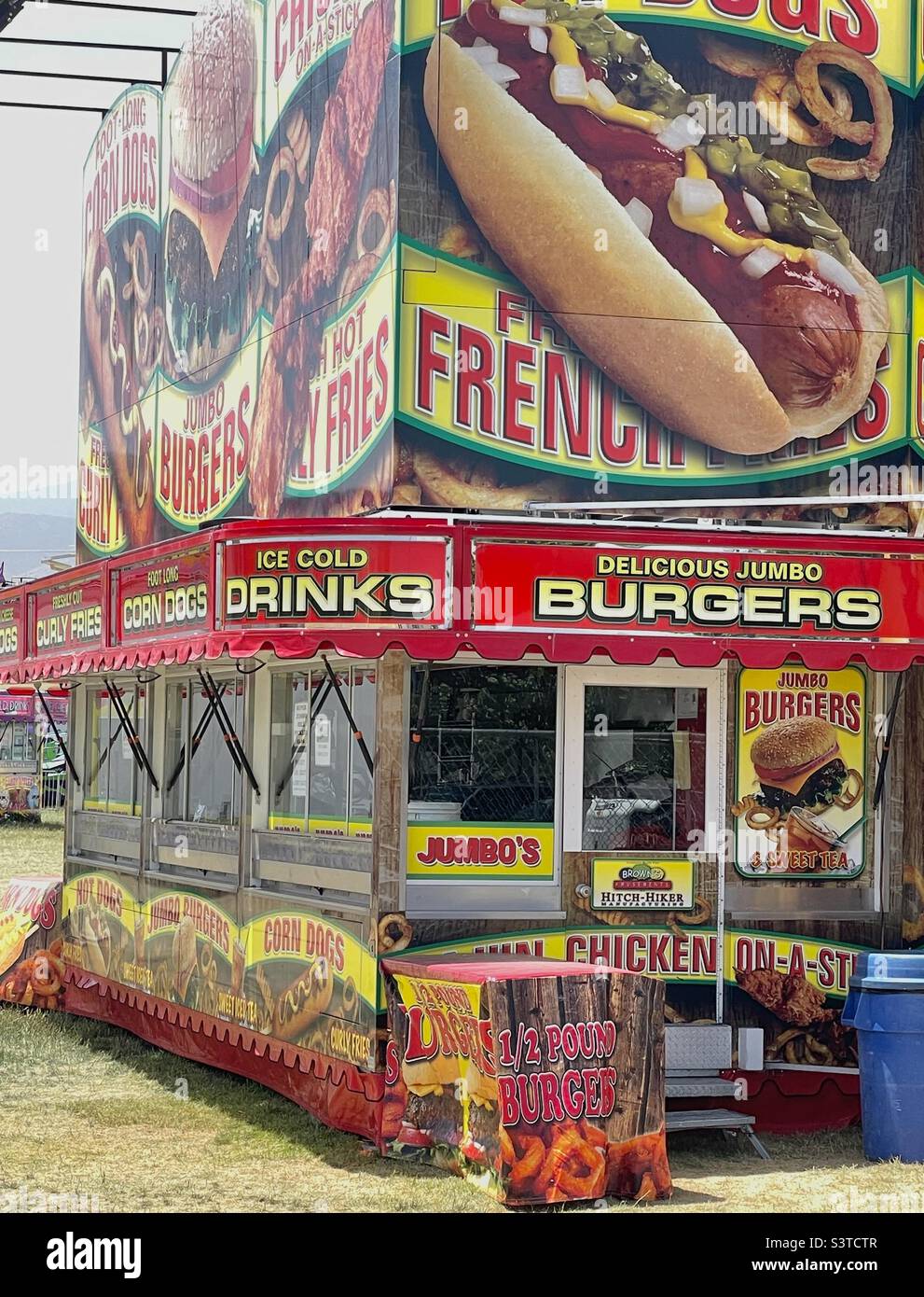 Ein Wanderkarneval, der für das jährliche West Fest in Utah, USA, eingerichtet wird. Ein Food-Stand wird mit kühner Werbung für Lebensmittel wie Hot Dogs, Burger, Pommes, Getränke usw. gesehen. Bald kommt die Eröffnung und die Massen. Stockfoto