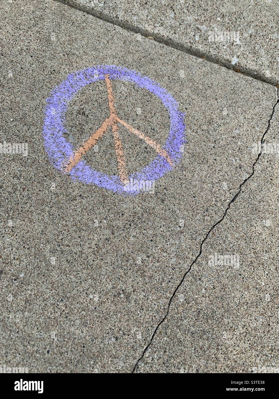 Friedenssymbol in violetter Kreide auf gesprungenem Bürgersteig gezeichnet - Smartphone-aufgenommenes Stockfoto