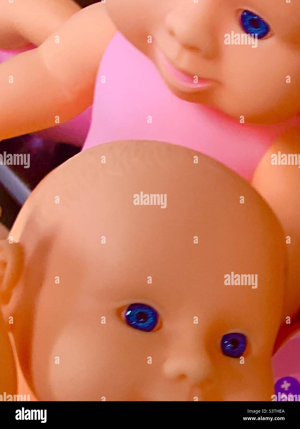 Weiße Plastikpuppen mit blauen Augen und rosa T-Shirts Stockfoto