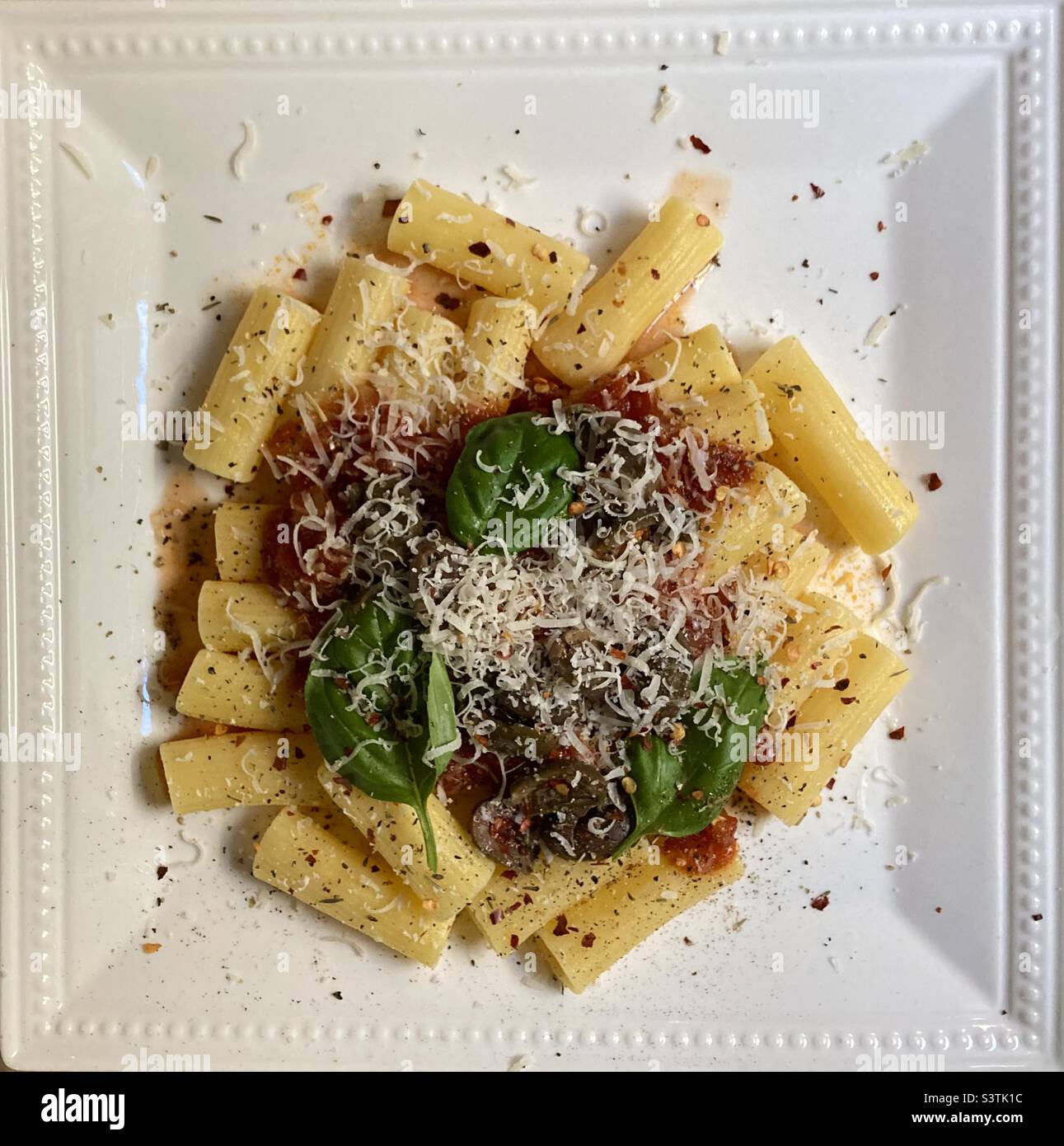 Maccheroni, hausgemachte Sauce, rissige Calabrese-Oliven, Parmigiano-reggiano, Basilikum, Frischer, rissiger Pfeffer und rote Paprikaflocken! Stockfoto