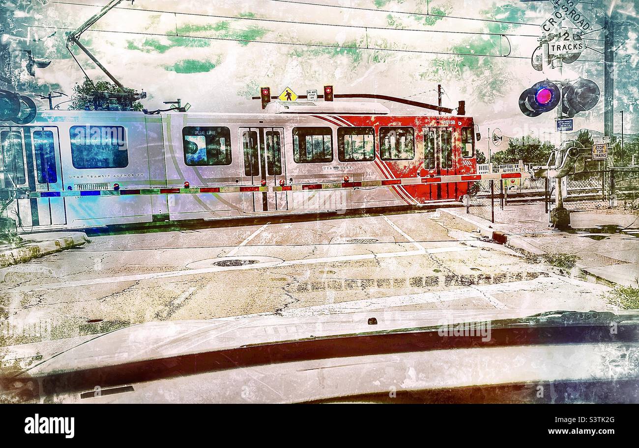 Das Auto hielt an einem Utah Transit Authority TRAX (Personenzug)-Übergang in Utah, USA. Grunge- und Alterungseffekte digital hinzugefügt. Stockfoto