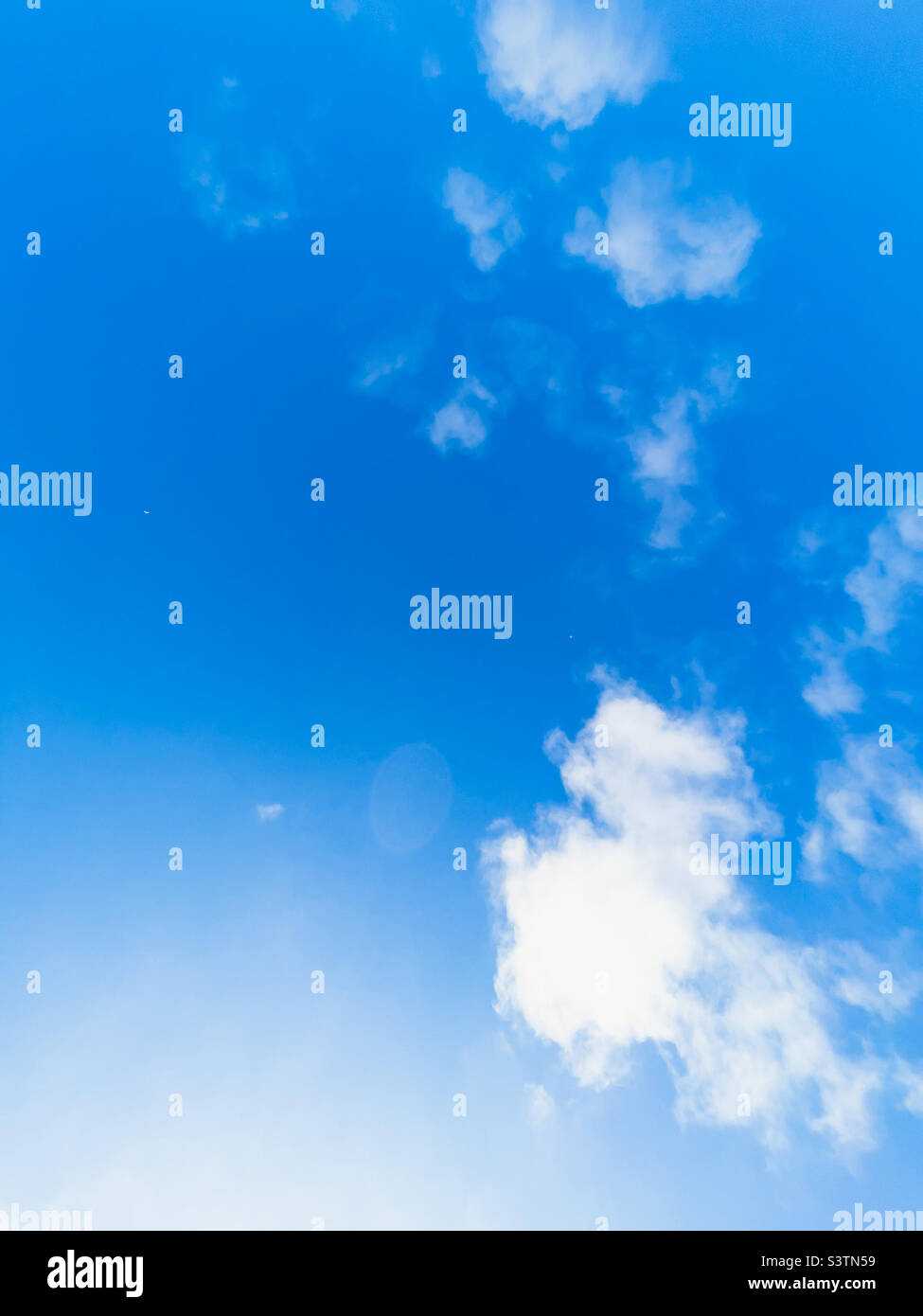 Blauer Himmel mit verstreuten weißen Wolken an einem sonnigen Sommertag. Stockfoto
