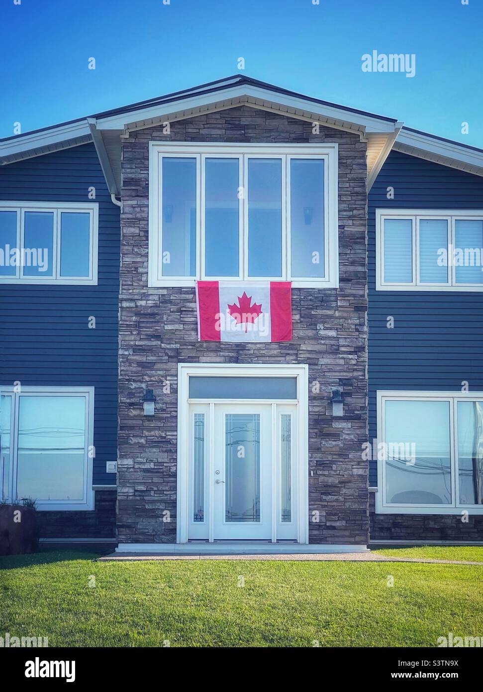 Kanadische Flagge auf der Vorderseite eines Hauses. - Smartphone-aufgenommenes Stockfoto