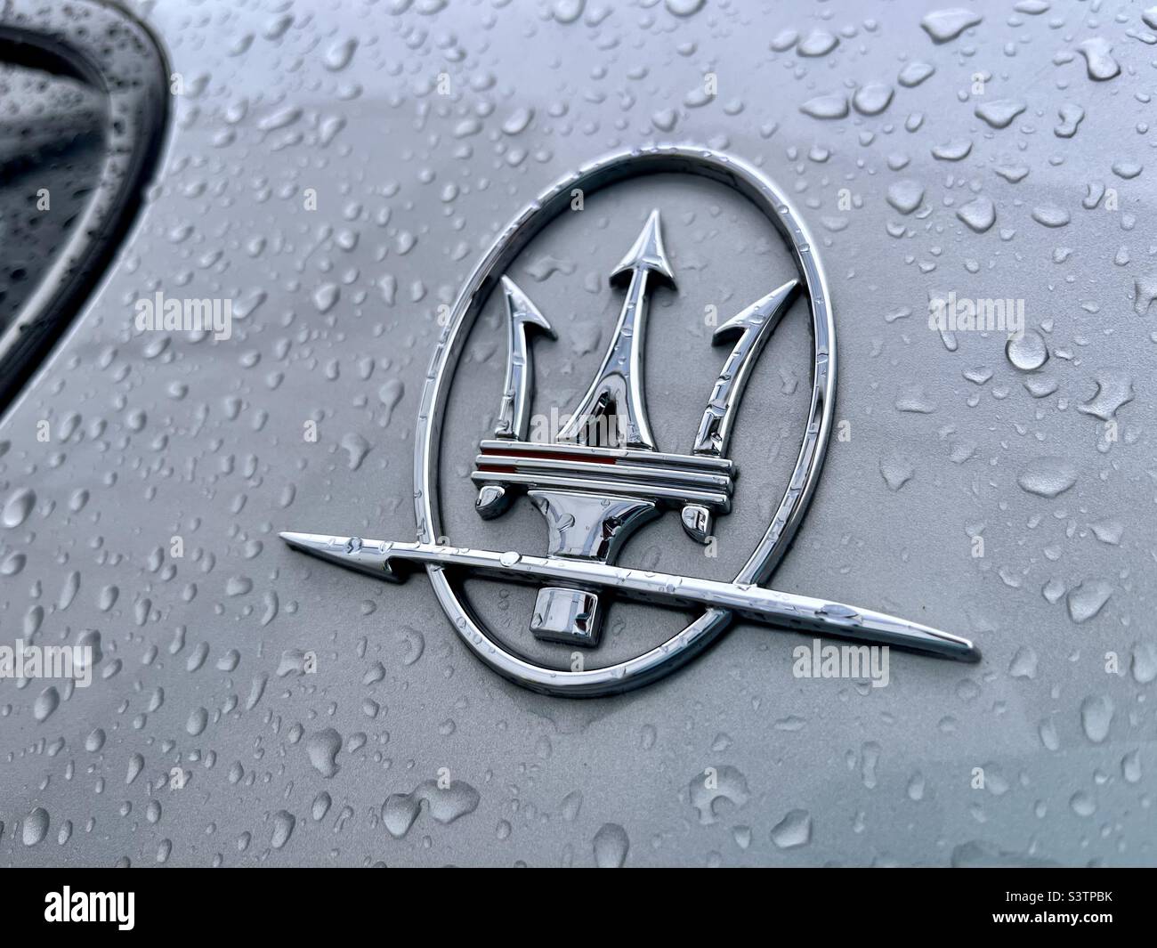 Maserati-Logo auf nassem Auto mit Regentropfen Stockfoto