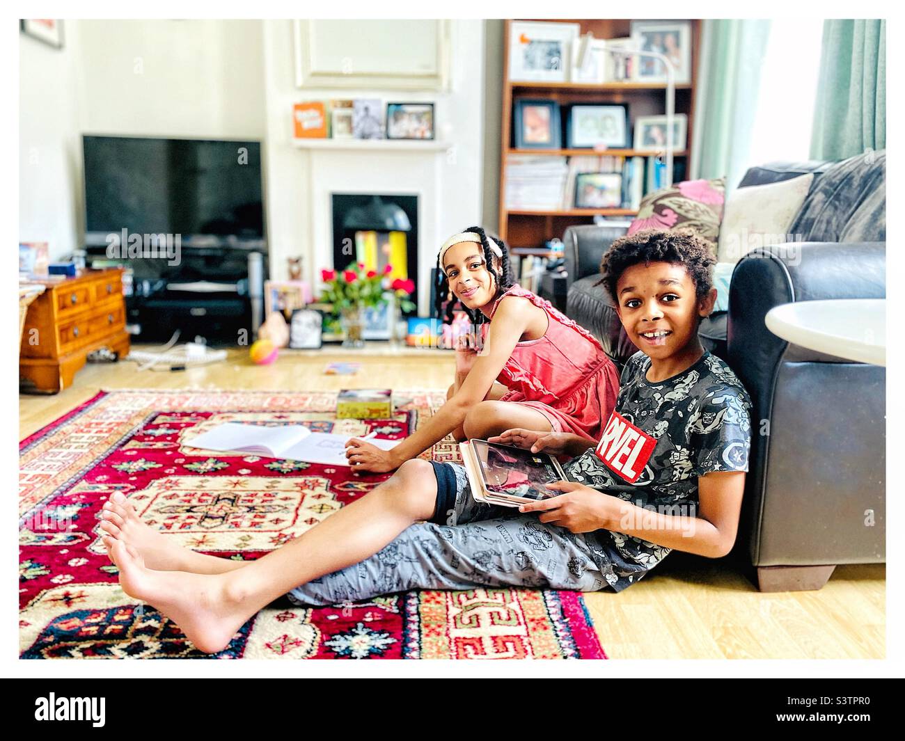 Multikulturelle Geschwister entspannen sich zu Hause. Stockfoto