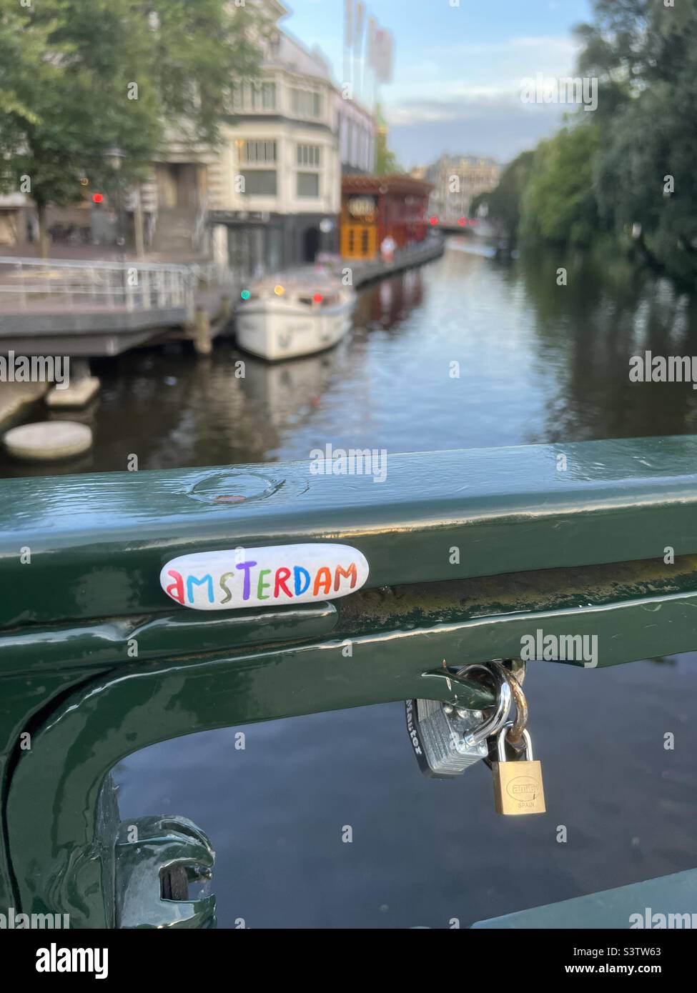 Amsterdam, einzigartiges Souvenir auf einem Steinmagneten und Blick auf den Kanal - Smartphone-aufgenommenes Stockfoto