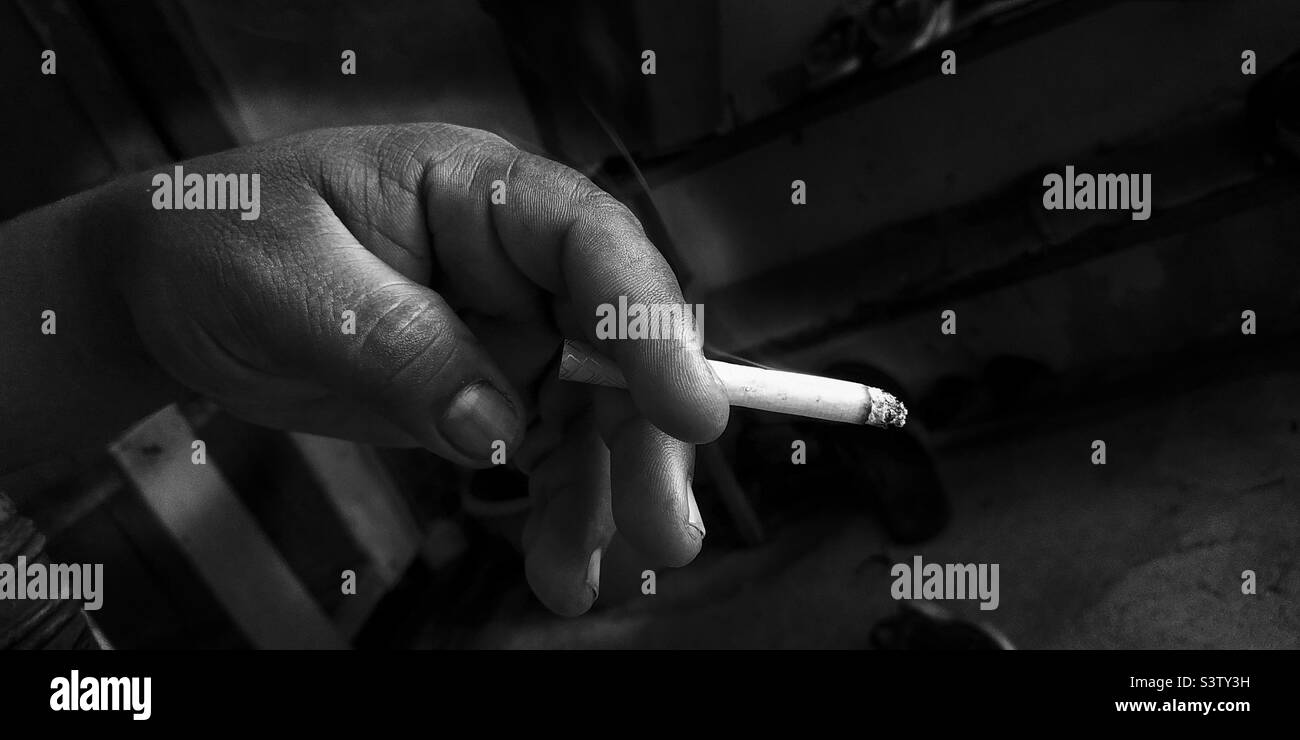 Ein Schwarz-Weiß-Bild von jemandem, der eine Zigarette hält Stockfoto