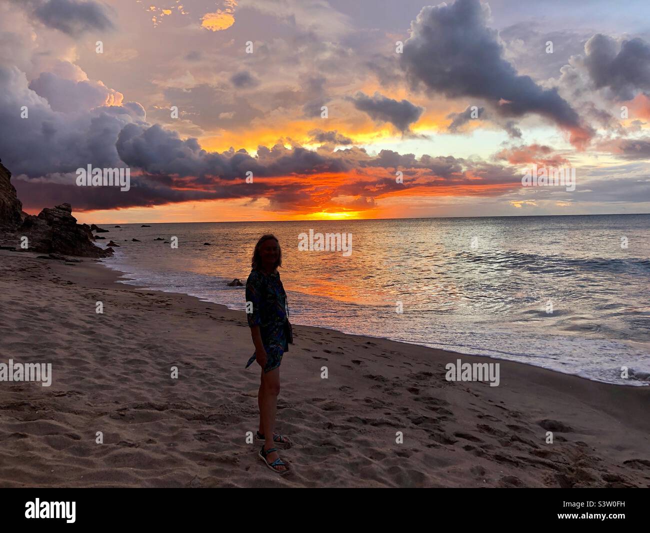 Silhouette einer Frau am Strand bei Sonnenuntergang. Stockfoto