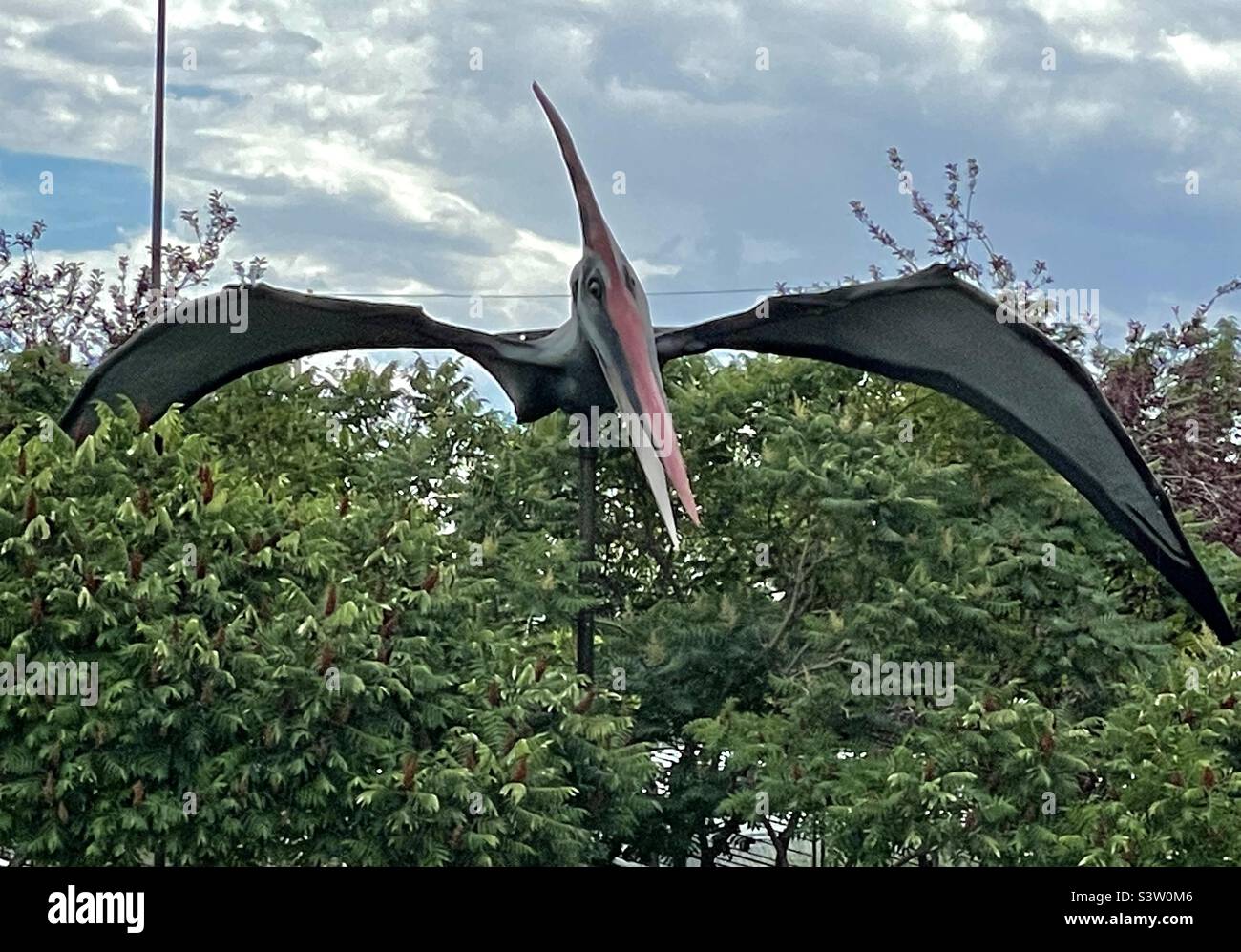 Im Innenhof des Dinosaur Museums in Vernal, Utah, USA, befinden sich verschiedene „Dinosaurier“-Figuren, die die Gäste, vor allem die Jungen, faszinieren und unterhalten. - Smartphone-aufgenommenes Stockfoto