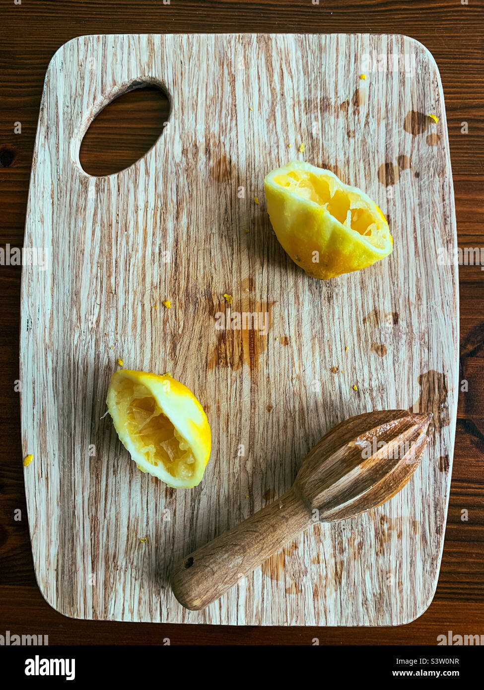 Zitronen gerieben und auf einem Holzbrett entsaftet Stockfoto