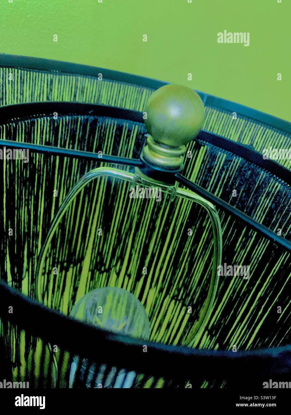 Schwarze Fransenlampe auf schwarzem Hintergrund mit Kopierraum - Smartphone-aufgenommenes Stockfoto