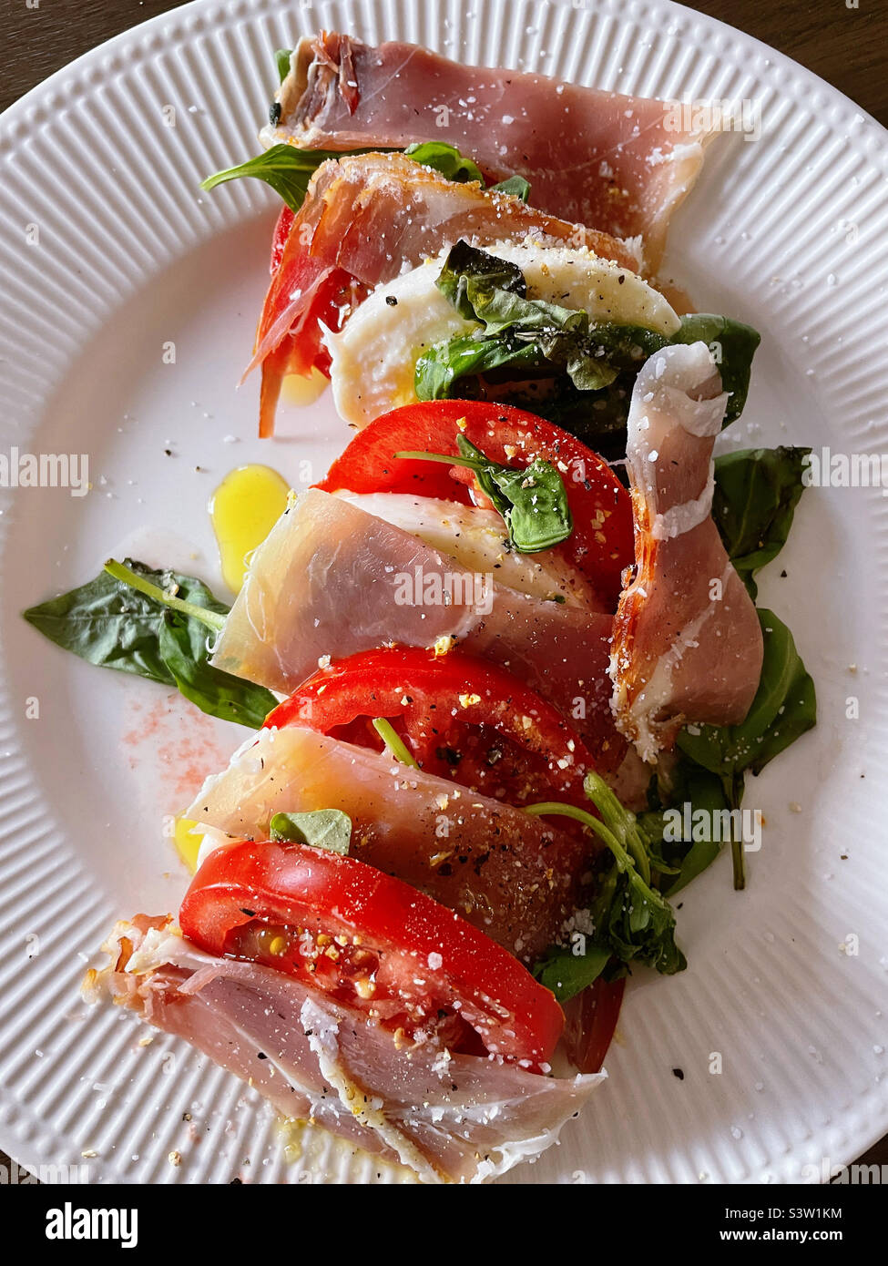 Nahaufnahme eines italienischen Gourmet-Gerichts mit Mozzarella-Käse, Prosciutto und reifen Tomaten und Basilikum, 2022, USA Stockfoto