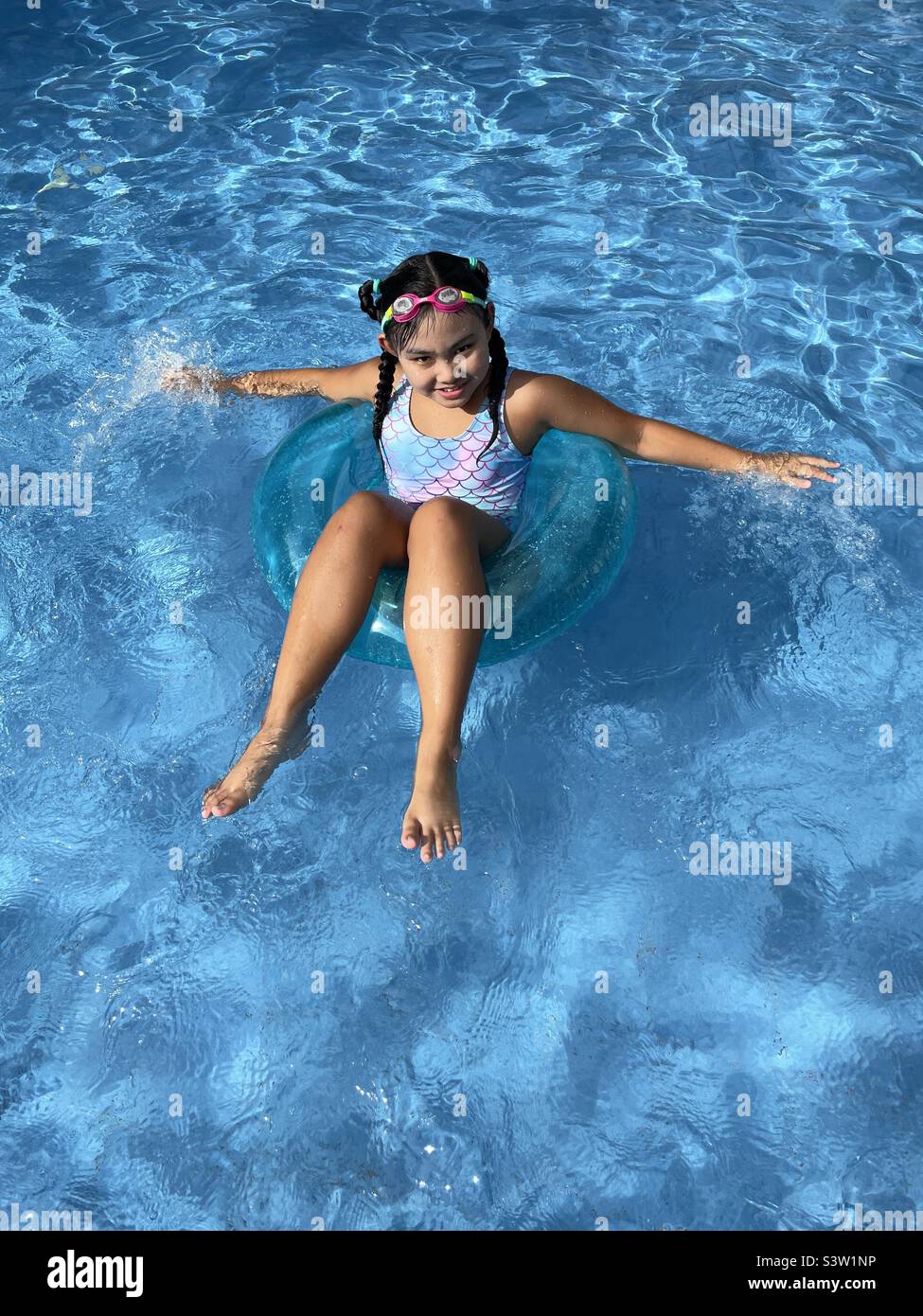 Asiatisches Kind auf einem schwimmenden genießen das Sommerwasser während der Schulferien Stockfoto