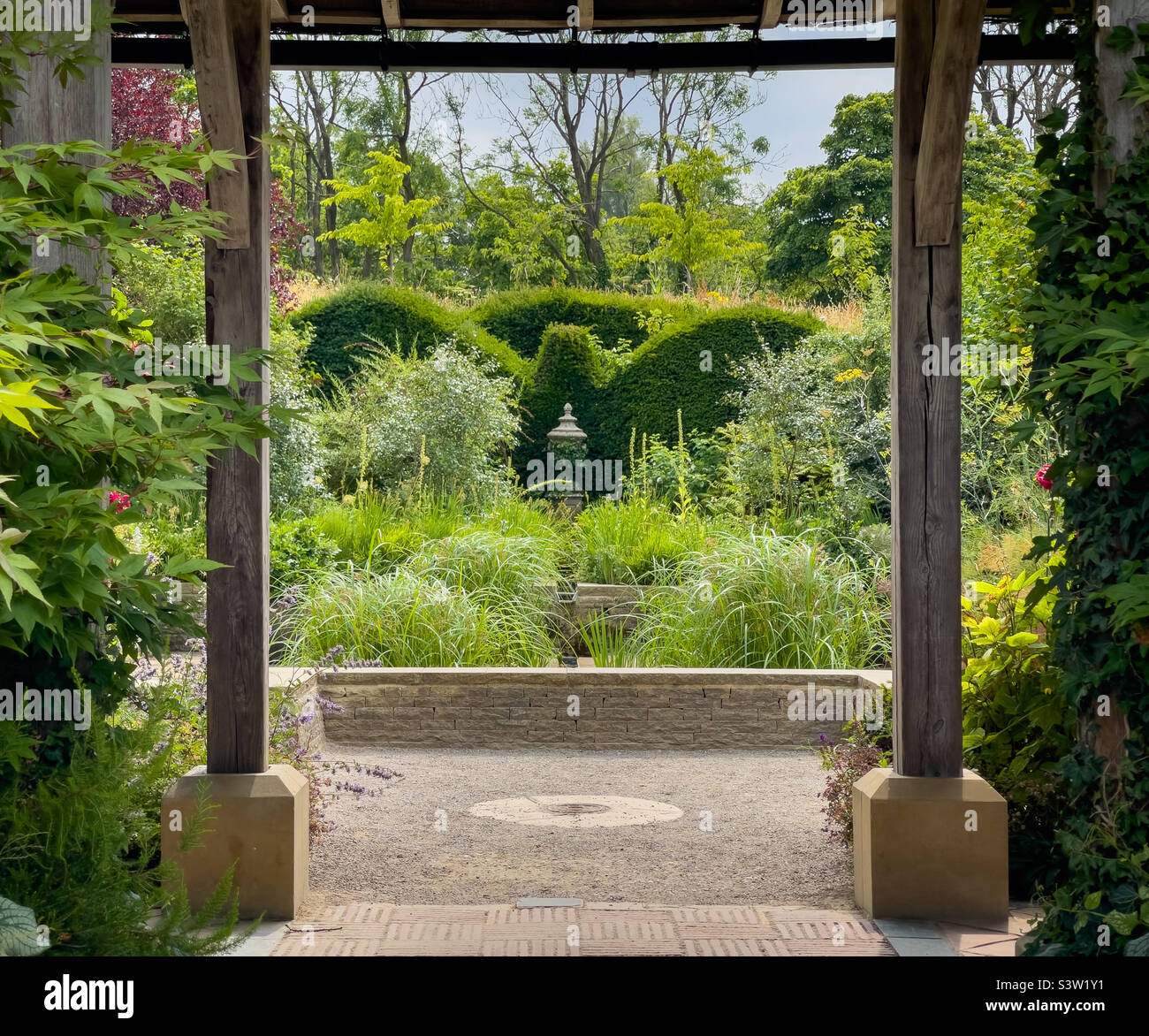 Edwardian Garden in Harlow Carr, eingerahmt von den Holzstützen des Pavillons, im Sommer. Harrogate UK Stockfoto