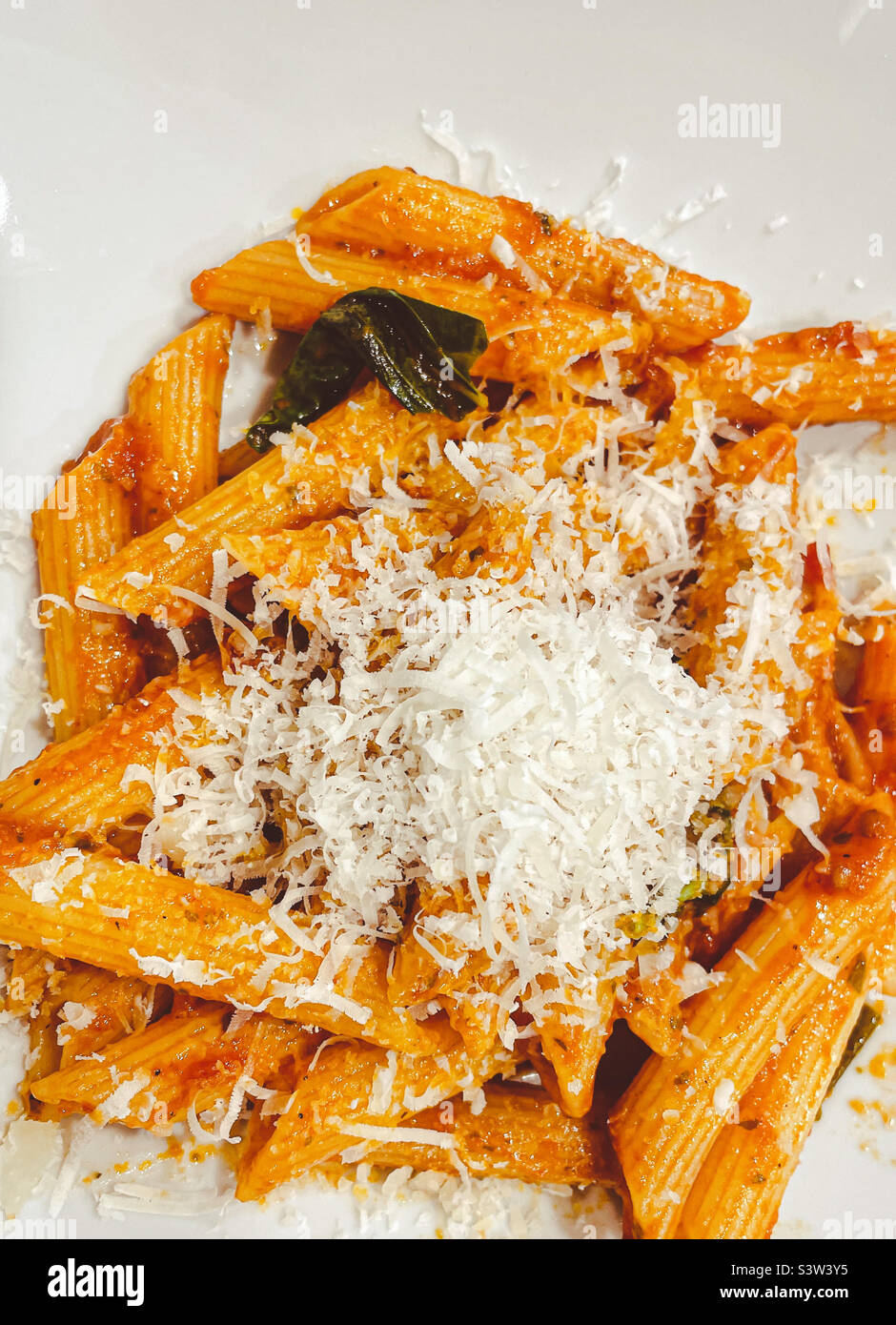 Nahaufnahme eines Tellers Penne Pasta mit Tomatensauce und frisch geriebenem Käse. Stockfoto