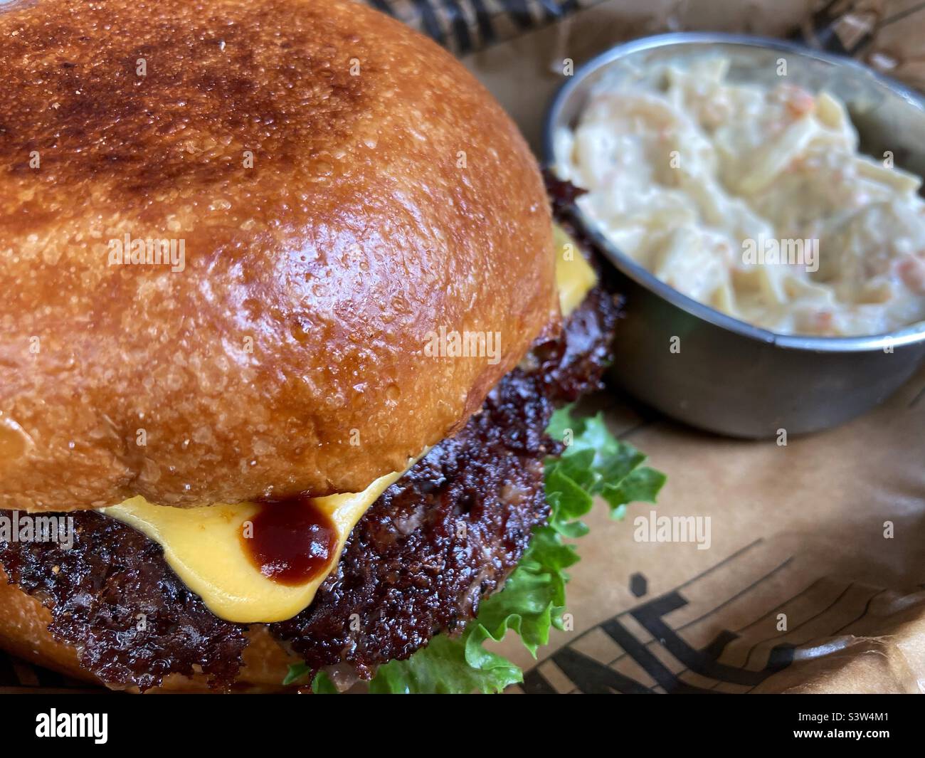 Ein Cheeseburger und eine Portion Krautsalatze Stockfoto