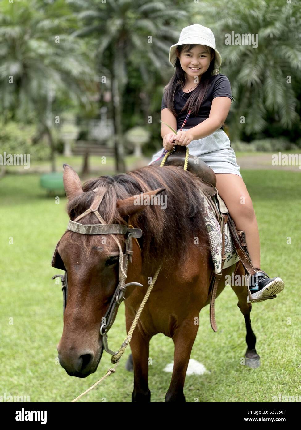 Asiatisches Kind genießt Reiten in der Natur Stockfoto