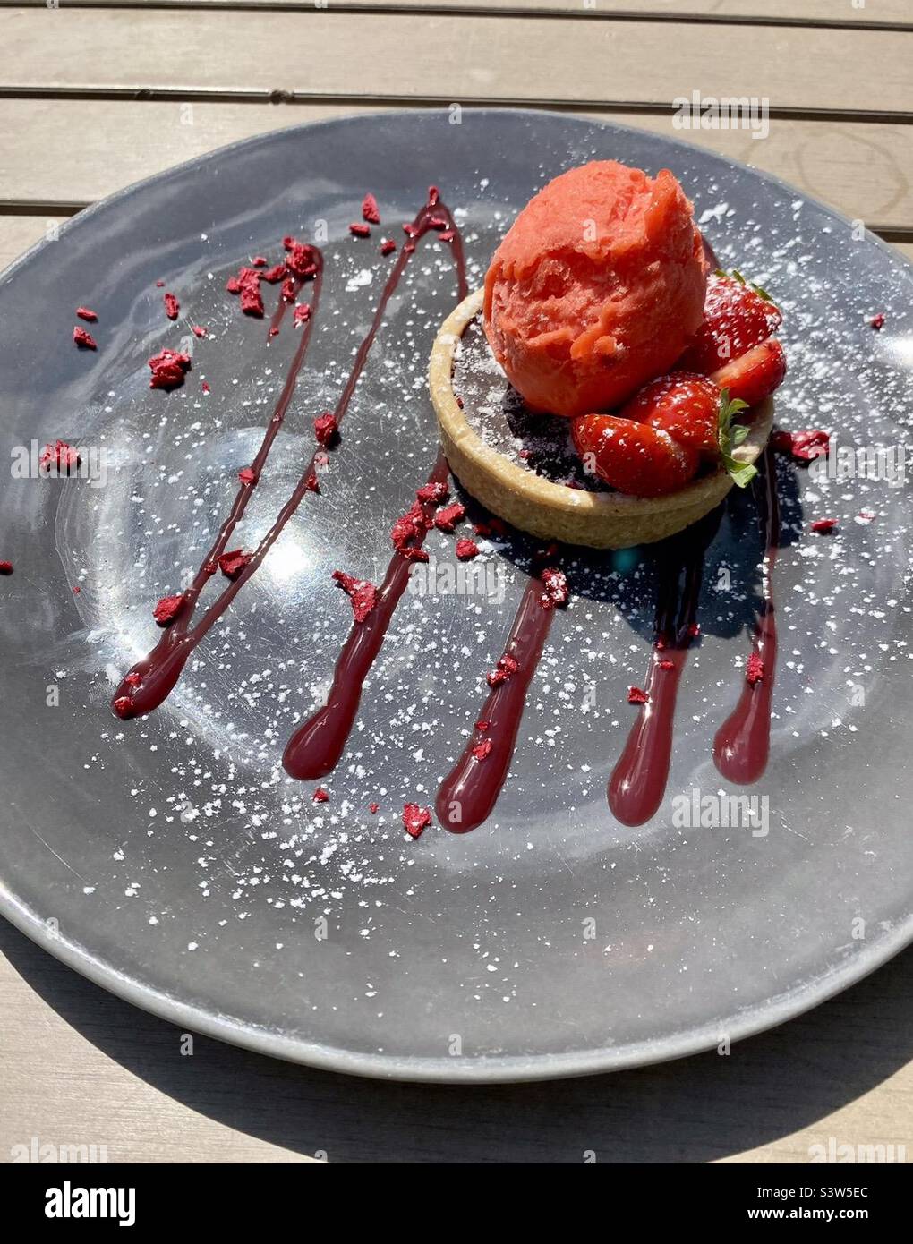 Vegane Schokoladenorangentarte mit Blutorangensorbet. Stockfoto