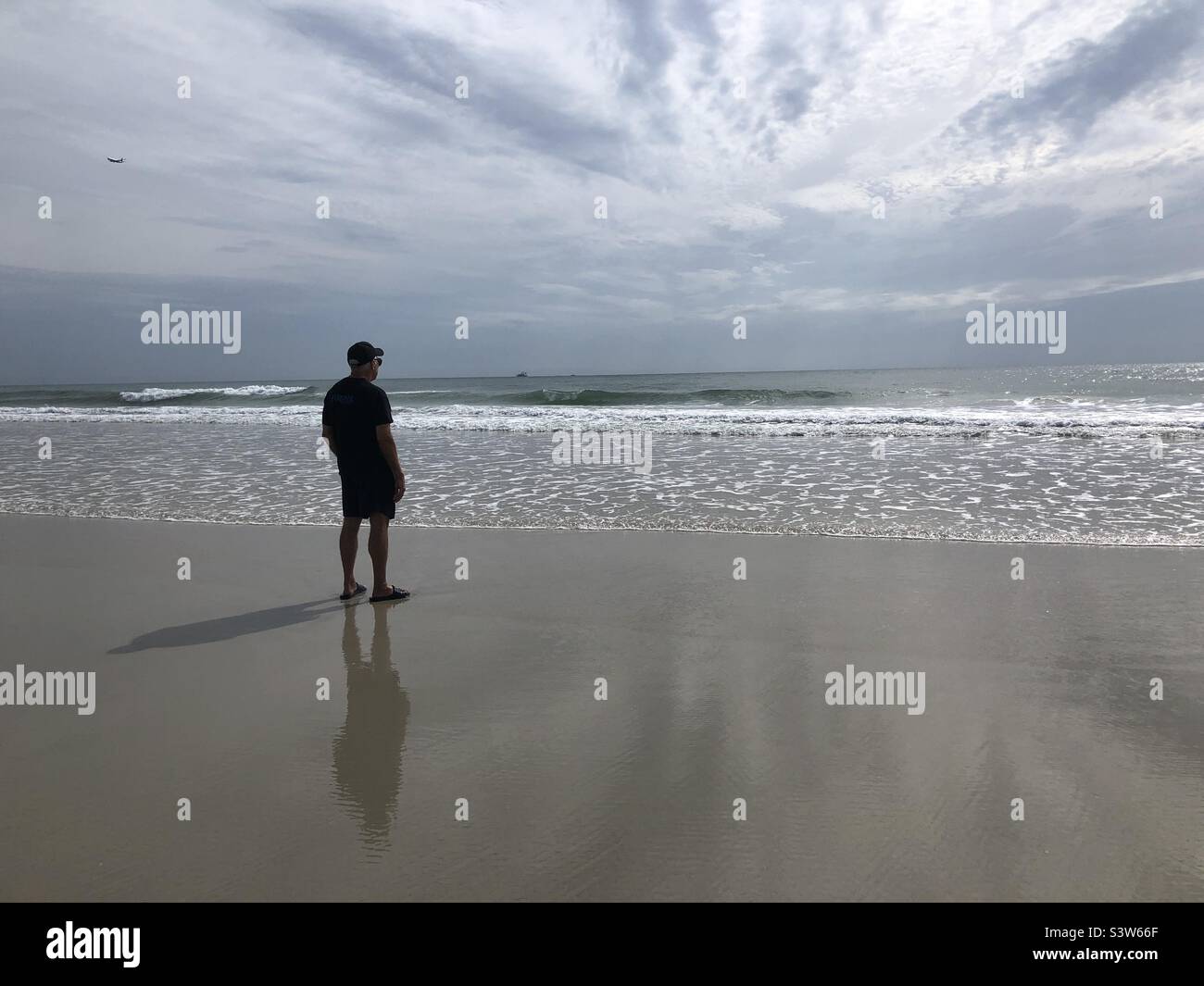 Ein älterer Mann im Daytona Beach Florida mit Blick auf das Meer Stockfoto