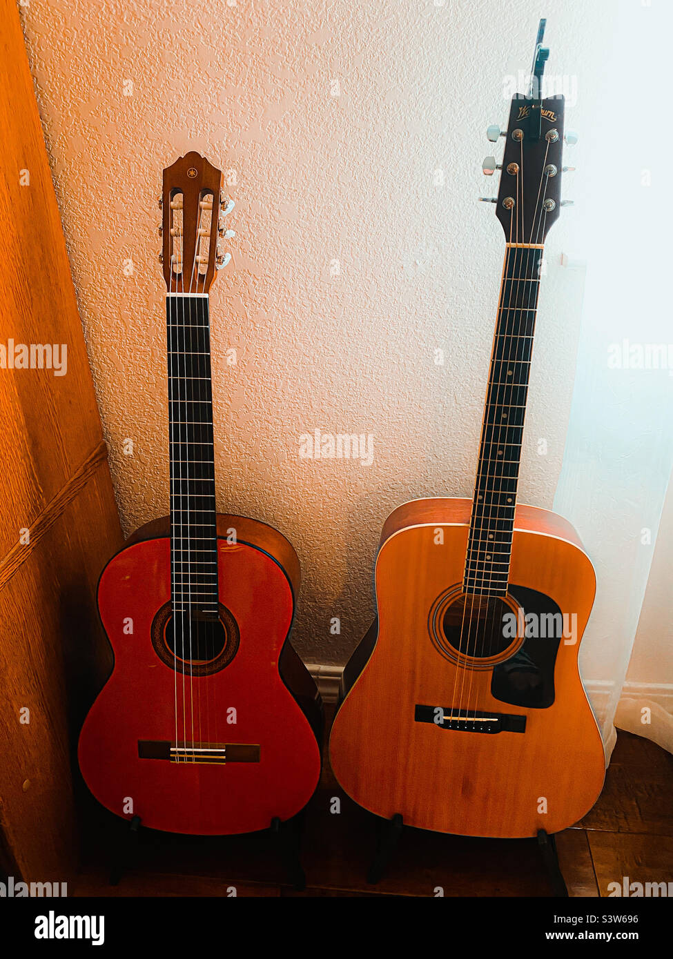 Ein paar Gitarren in einer Ecke eines Raumes. Stockfoto