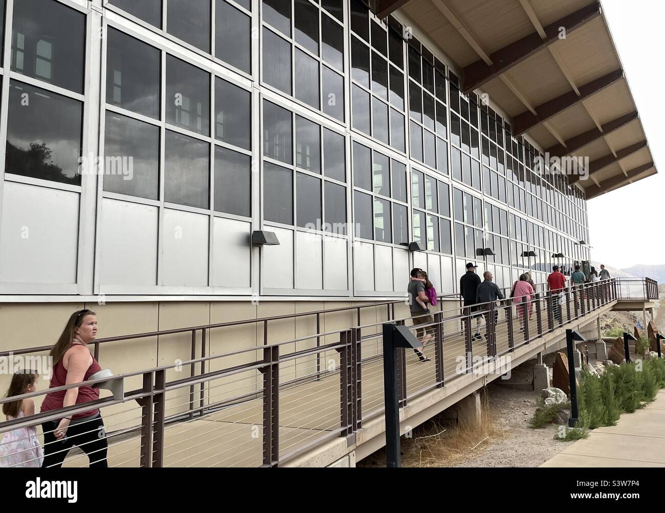 Touristen und Besucher, die zum Eingang der sehr großen öffentlichen Dinosaurierknochen- und Fossilausstellung in Vernal, Utah, USA, gehen, die vom National Park Service betrieben wird. Stockfoto