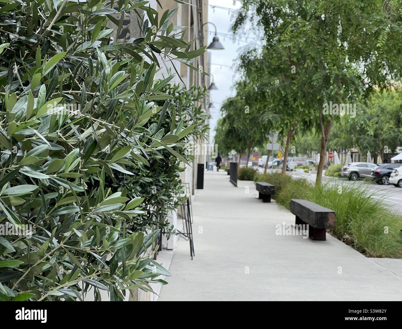 LOS ANGELES, CA, APR 2022: Blick auf den Bürgersteig in The Row, sanierte städtische Stätte im Downtown Produce District. Konzentrieren Sie sich auf den Vordergrund mit einer anonymen Person in der Ferne - Smartphone-aufgenommenes Stockfoto