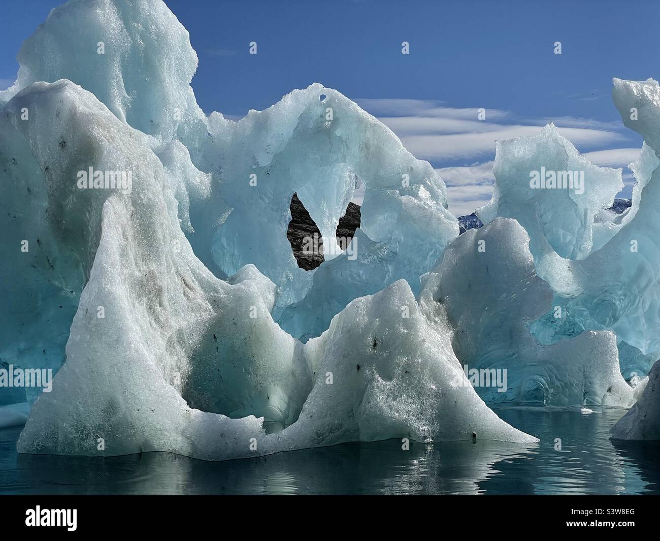 Eisberg in bizarrer Form an einem sonnigen Sommertag in einem Fjord in Ostgrönland schmelzen Stockfoto