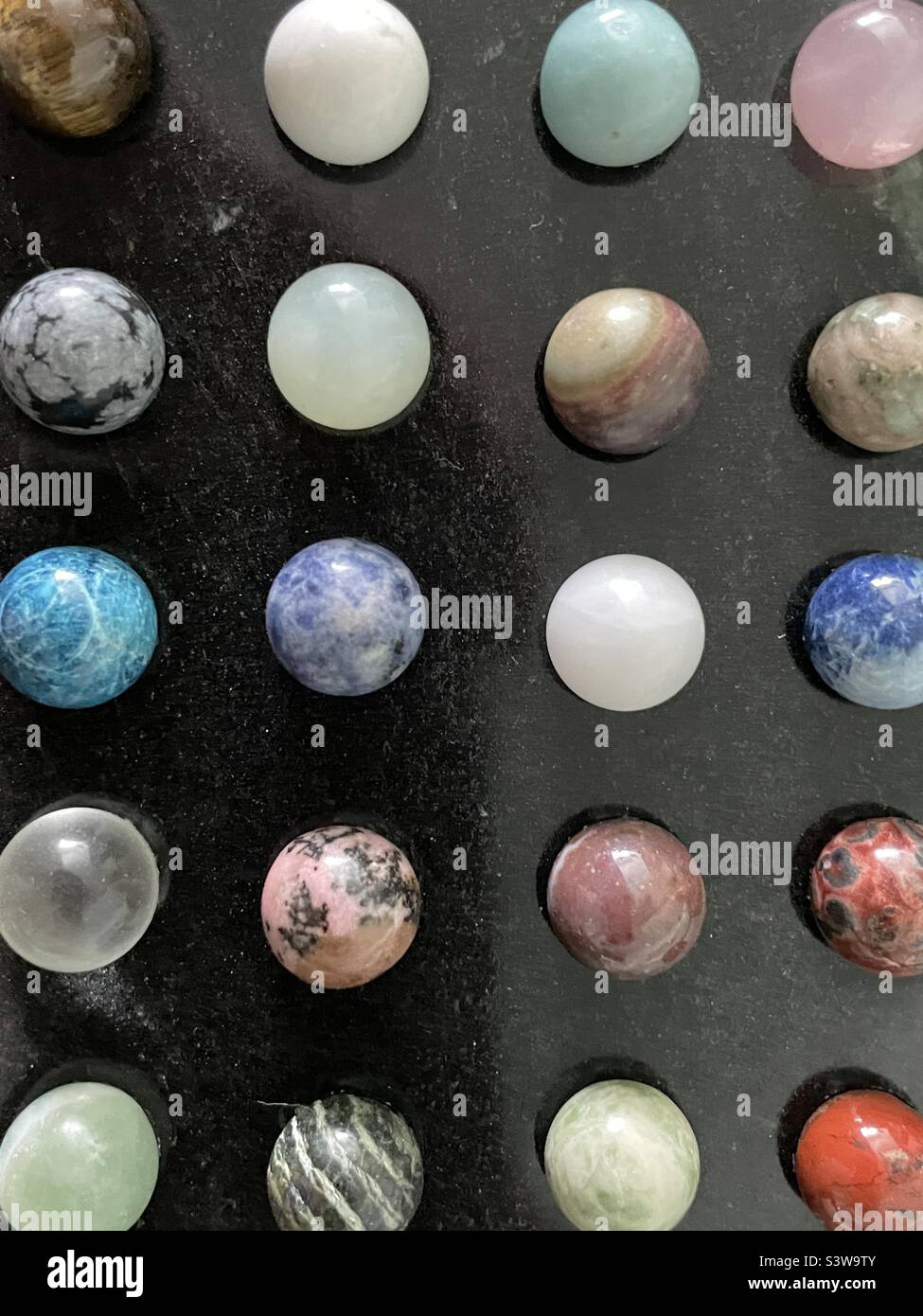 Eine oben und gezoomte Ansicht eines aus Stein, Onyx-Marmor gefügten Chinese Checker Spielbretts. Bildet eine symmetrische und geordnete Zusammenfassung mit Farbtupfen, Design und Textur. Stockfoto