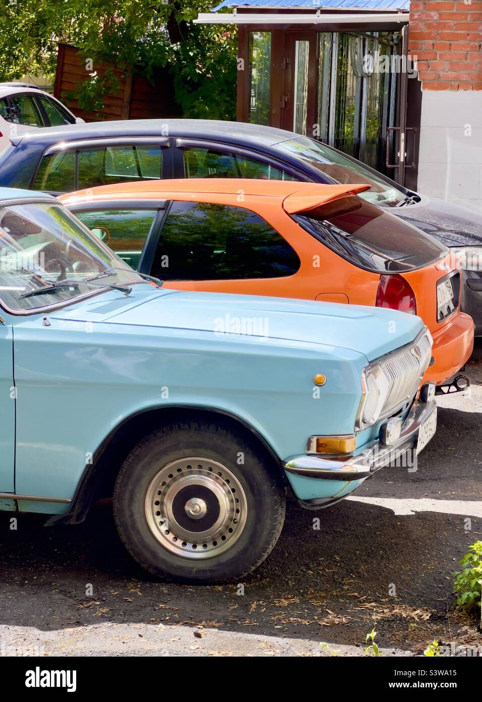 Mehrfarbige Autos orange blau verschiedenen Ländern in Russland und Japan vintage und verwendet. Transportkonzept Stockfoto