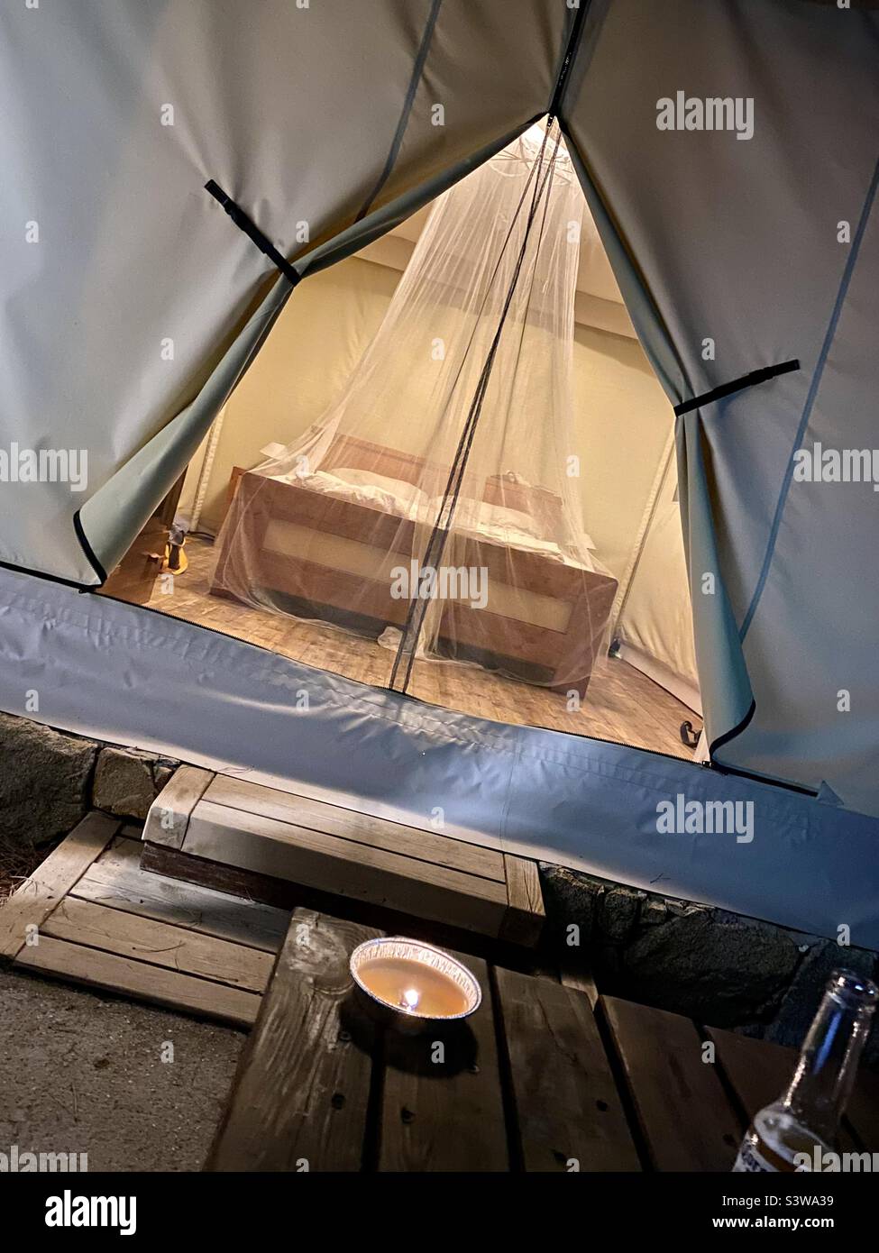 Gemütlicher Innenblick auf ein Glamping-Zelt mit Kerzenlicht-Atmosphäre Stockfoto