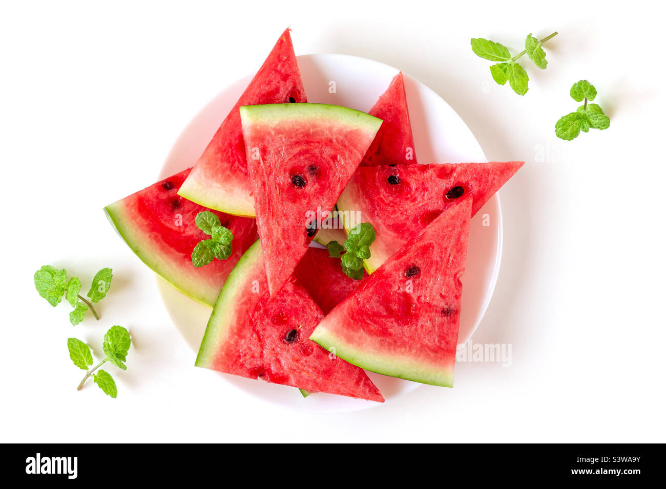 Frische, saftige Wassermelone auf einem weißen Teller mit Minzblättern, Draufsicht - Smartphone-aufgenommenes Stockfoto